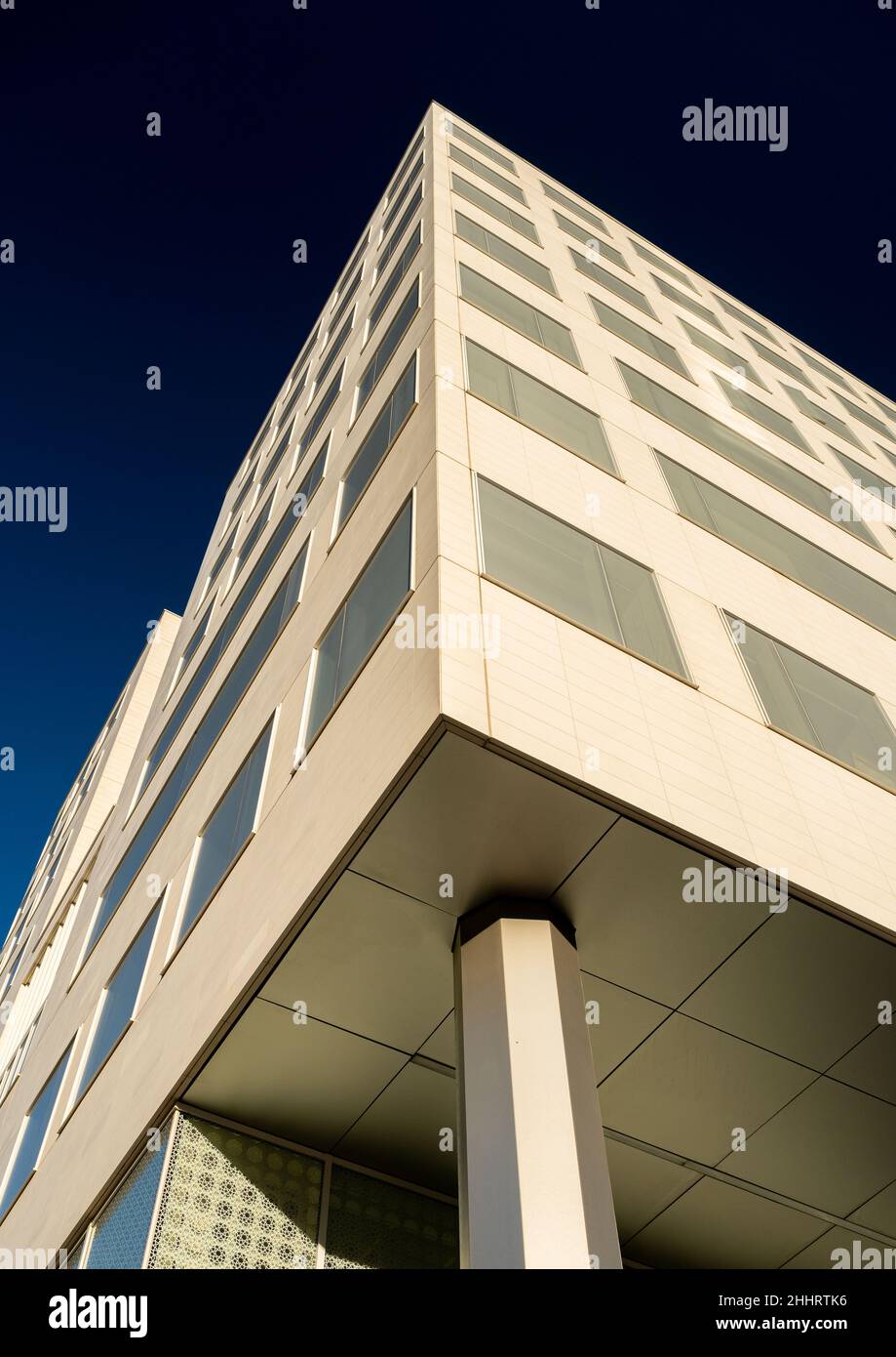 Detail of high rise tower block with windows and vents against a blue sky Stock Photo