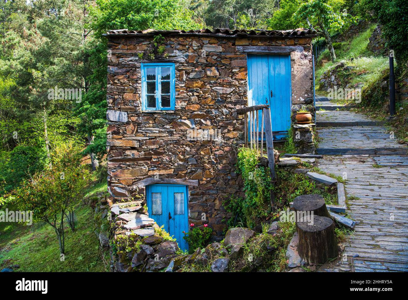 Old stone house with rustic blue wooden doors and windows in the village of Cerdeira, Portugal Stock Photo