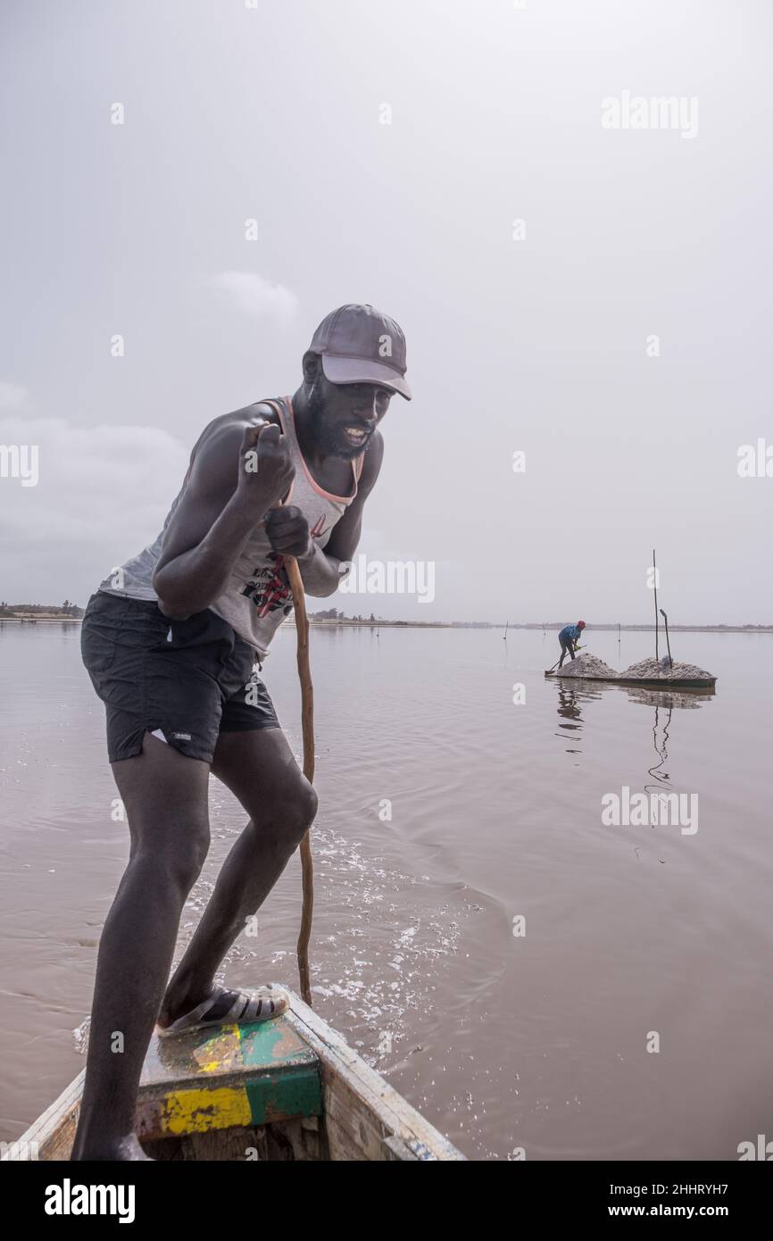 Boatman sailing on the Pink Lake off the coast of Senegal Stock Photo