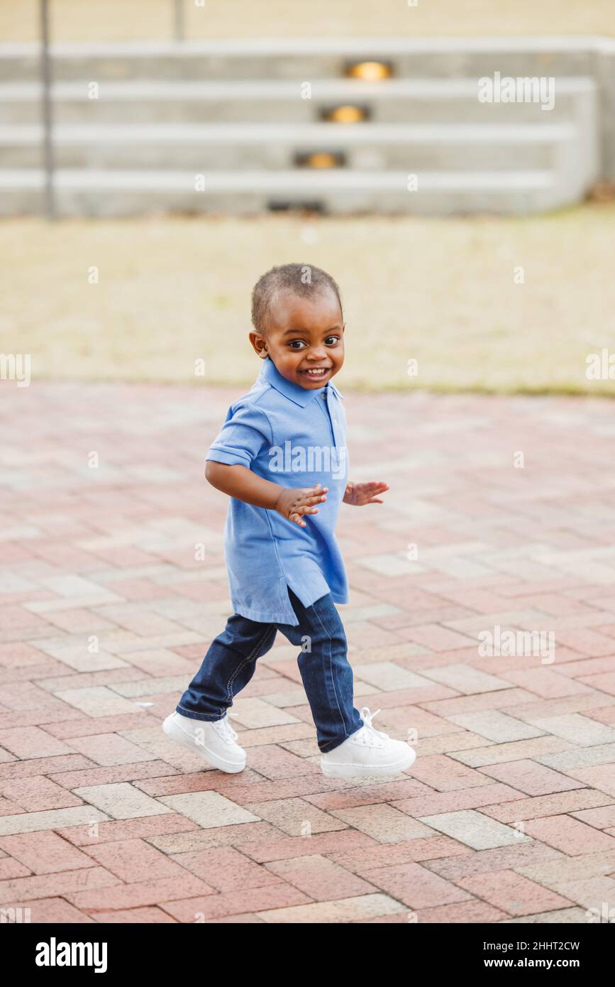 A cute one year old toddler walking outside Stock Photo