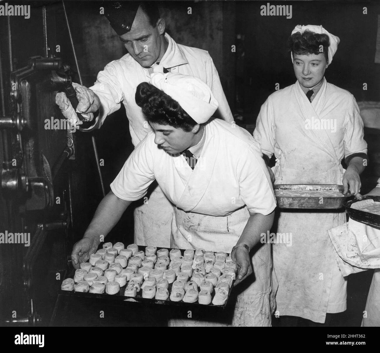 Women baking Swiss Rolls and sultana puddings, put their desserts into the oven during the Diploma course at the John Heddon RAF Cookery School in Hatton. 7th November 1944. Stock Photo