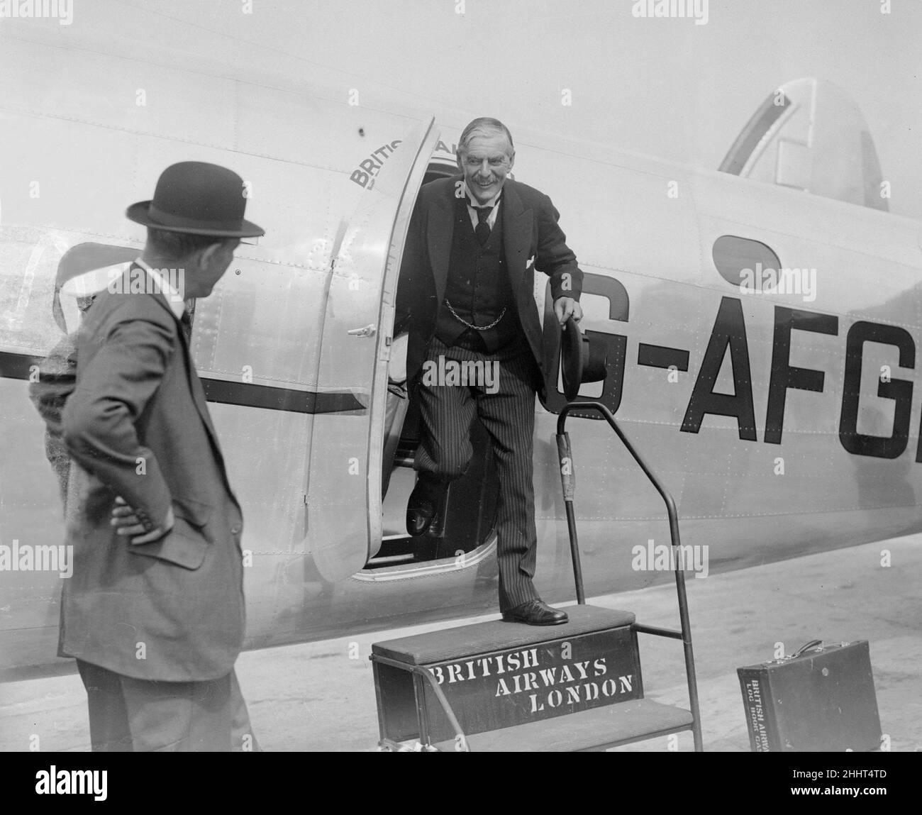 British Prime Minister Neville Chamberlain greeted by Lord Halifax (in bowler hat) on his arrival at Heston airport following one of his meetings with German Chancellor Adolf Hitler in his Berchtesgaden mountain retreat. 16th September 1938. Stock Photo
