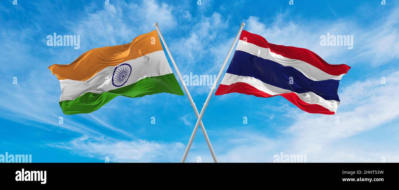 crossed national flags of India and thailand flag waving in the wind at ...