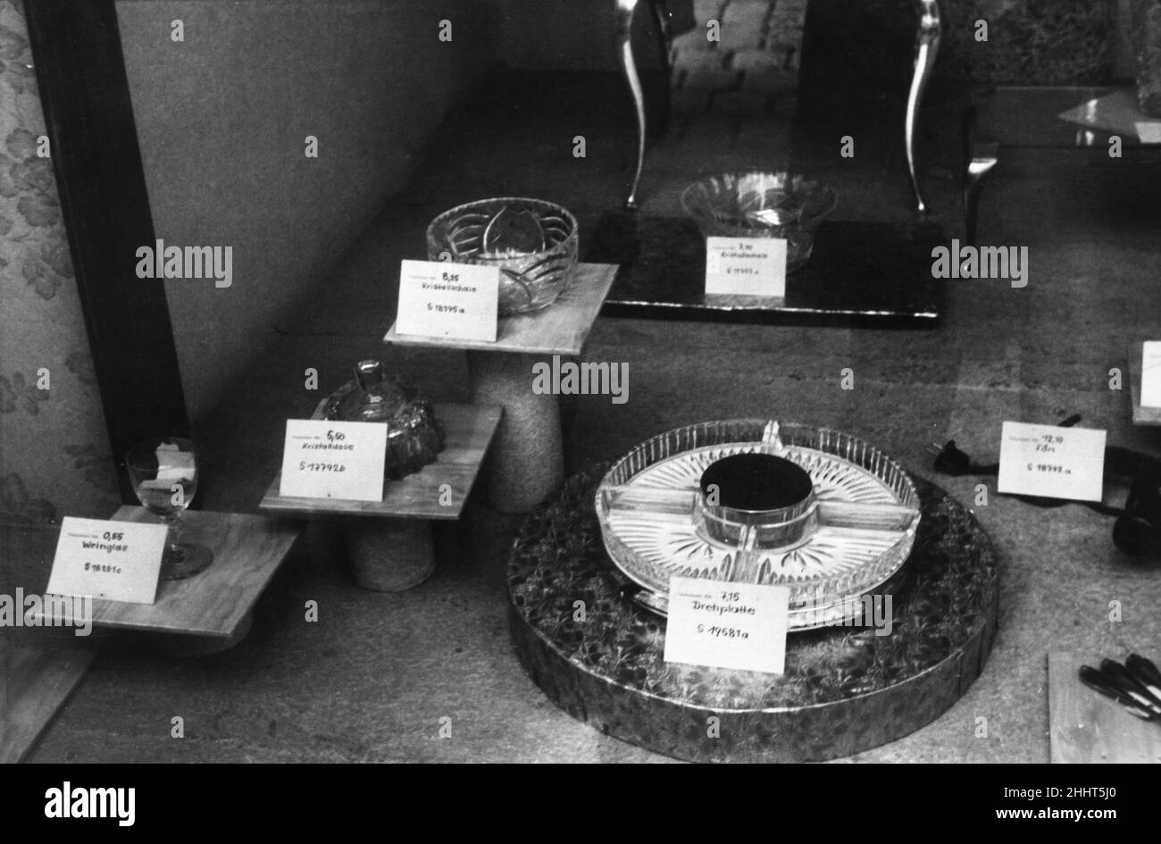 Items for trade  on display in a shop window  in Luneburg, Germany after the Second World War. After the war there was  a scarcity of vital necessities such as food, clothing and every day commodities such as appliances and household utensils. As none of these were being manufactured the only option left to Germans to acquire these things was through a trade barter.  In all the big German towns and cities, the Barter Emporium sprung up. An item would be displayed with a ticket stating the cost (pre war value) and what the owner would accept in exchange.  2nd October 1945. Stock Photo