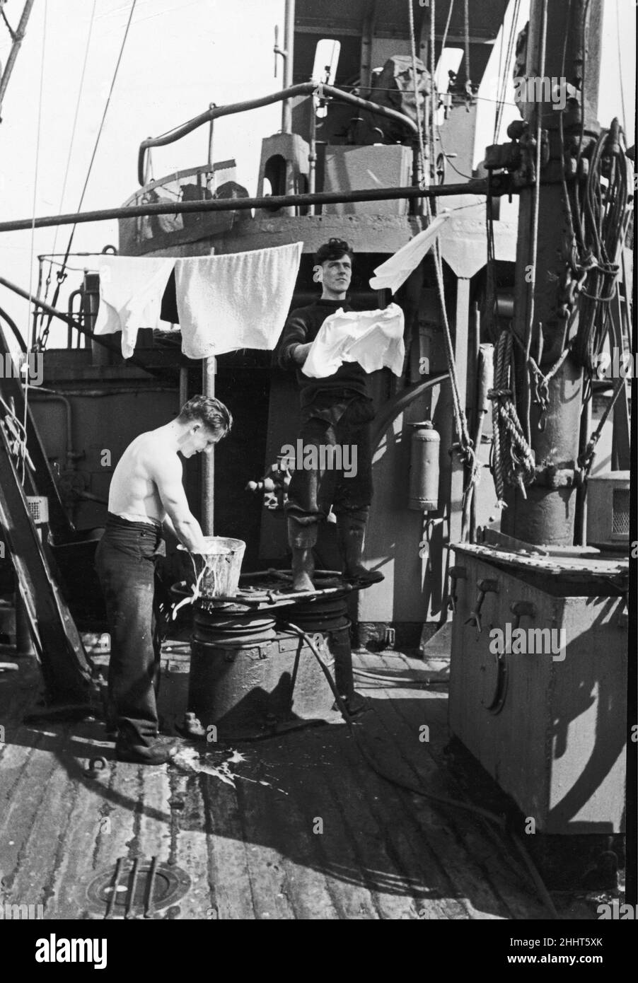 Two of the crew of a Royal Navy minesweeper on coastal convoy duties off the south west coast of England  find time between alerts to wash their smalls. September 1942 Stock Photo