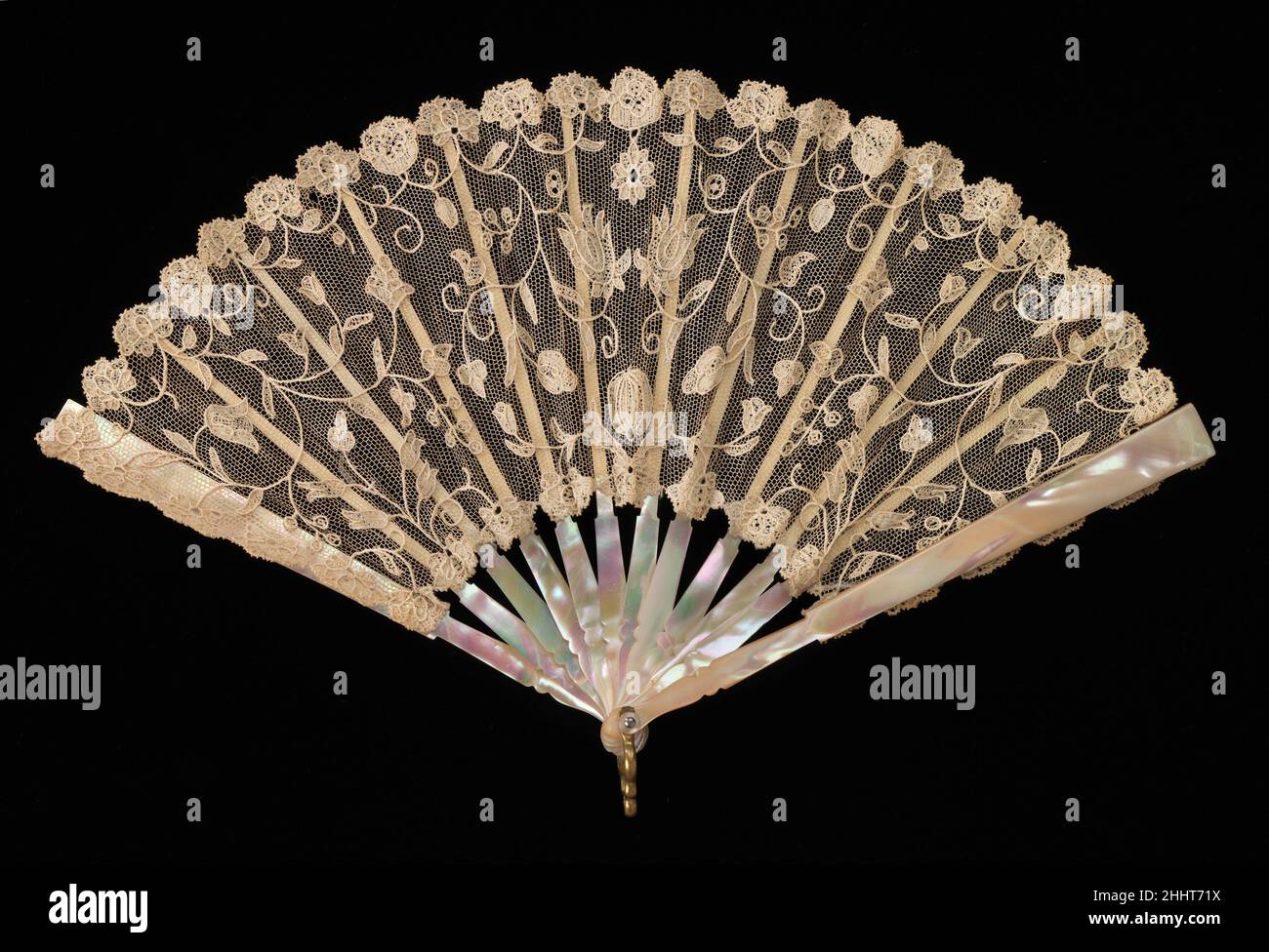 Fan fourth quarter 19th century European This is probably a child's fan but worked with very fine materials. The needle-made lace of the leaf is handmade and the placement of the motifs indicates it is made precisely for a fan of this size and shape; particularly charming is the melon shape beneath the two flowers at the center of the leaf.. Fan  156846 Stock Photo