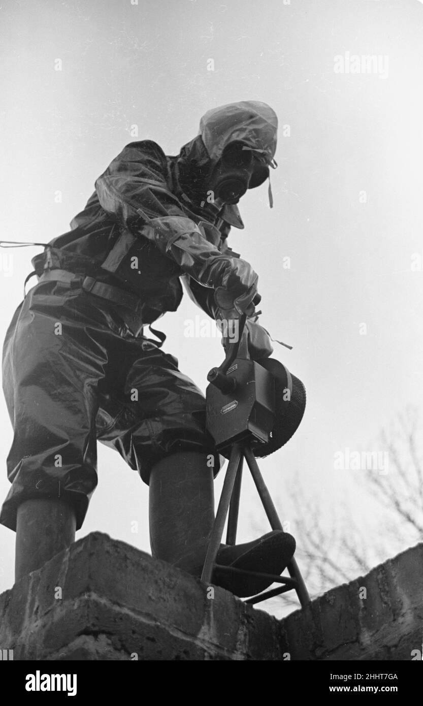 Preparations for war. ARP warden operates the air raid siren during a civil defence gas attack exercise in Kingston. June 1938. The clothing worn in this image would evolved into the NBC suits used the British Army today. Stock Photo