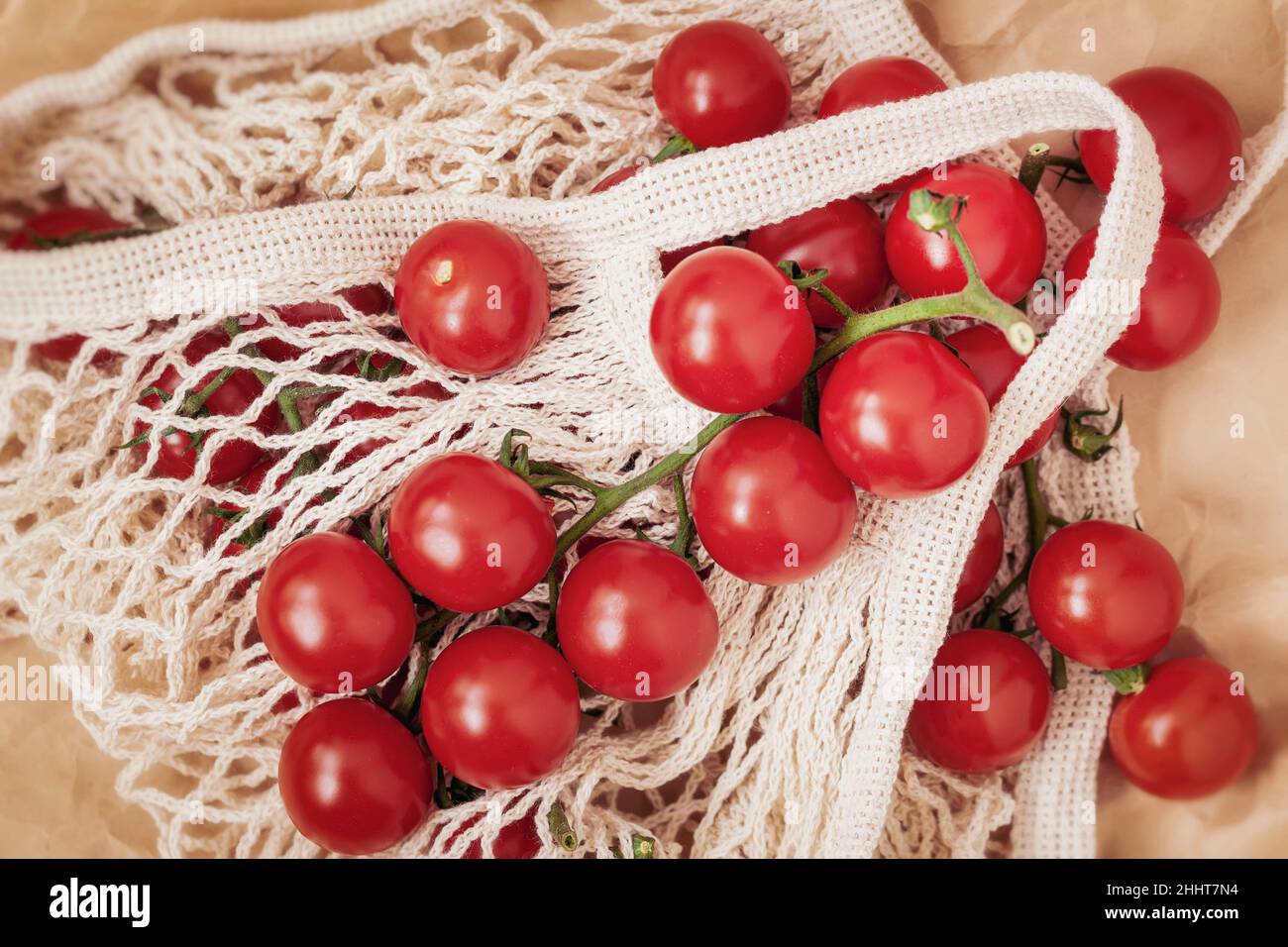 White ecofriendly shopping net mesh bag with tomatoes, top view. Eco
