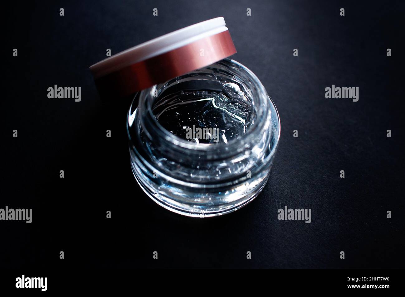 transparent jar with moisturizing gel with hyaluronic acid on a black background Stock Photo