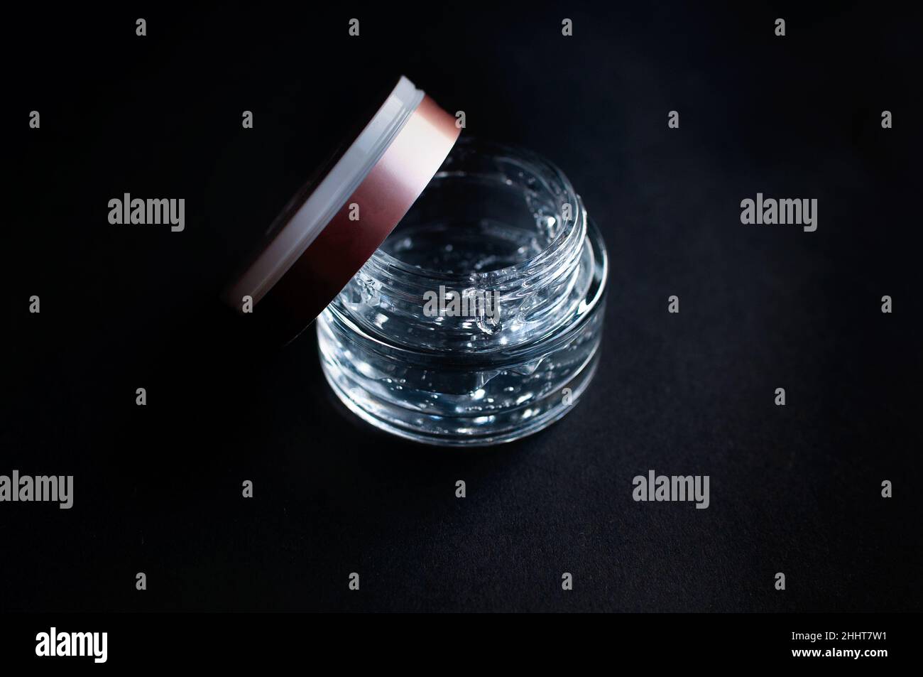 transparent jar with hyaluronic acid moisturizing gel on a black background Stock Photo