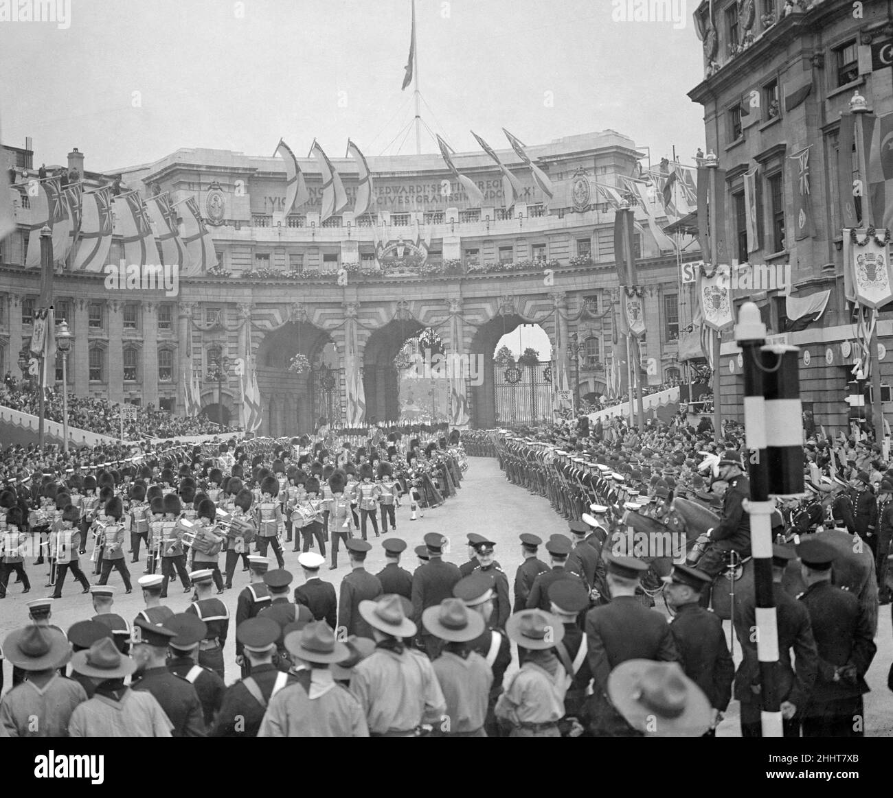 Coronation of King George VI.The procession passes through Admiralty Arch on The Mall  as thousands of people watch from the side of the road. Royal Scots guards marching through accompanied by pipe players. 12th May 1937. Stock Photo