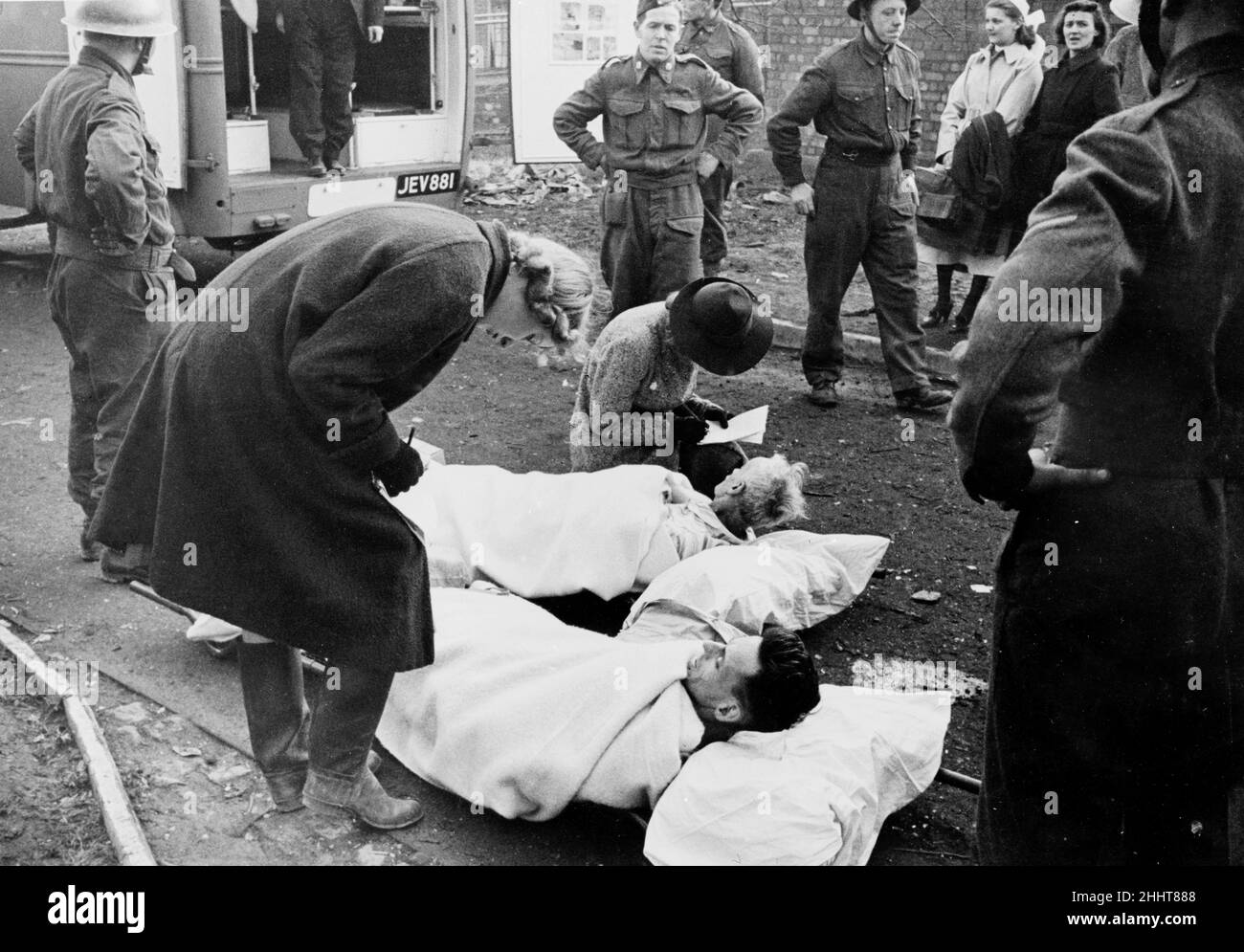 Rescue workers take names and address of injured air raid victims ...