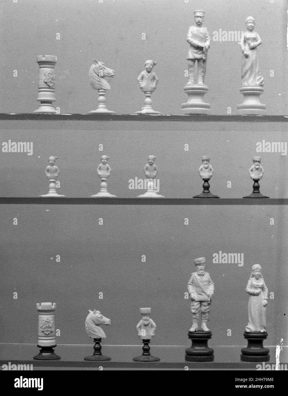 Chessmen (32) late 19th century German The two kings resemble Kaiser Wilhelm of Germany and Czar Alexander III of Russia, and resemblances to the Empress Augusta and Czarina Maria Feodorovna may be intended in the queens. The reigns of the Kaiser and Alexander III overlapped from 1887 to 1894. This period may thus be taken as the probable time in which the set was made. The initials J S in monogram within a shaped shield on the four rooks are probably those of the original owner.. Chessmen (32). German. late 19th century. Ivory. Chess Sets Stock Photo