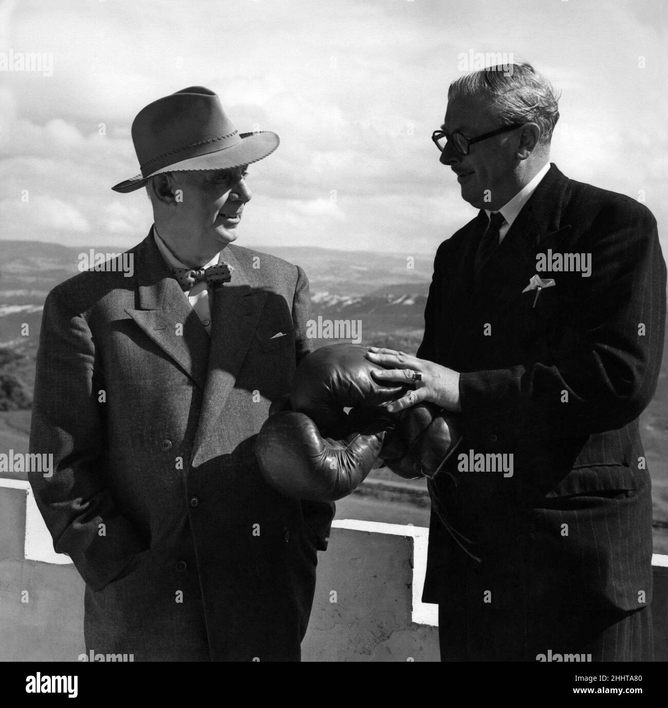 I.. Jack Beynon of California with Leslie Salts on the balcony of Randy's Bar on the Gt. Orme at Liandudno N Wales.The castle was sold in 1946 to Mr Leslie Salts, who opened it to the public for 20 years, attracting nearly ten million visitors and earning Gwrych the sobriquet of ¥the showplace of Wales. In 1989 the castle was sold to a property developer in California and during 16 years of absentee ownership the roofs have collapsed bringing down ceilings and floors. July 1953 P011468 Stock Photo