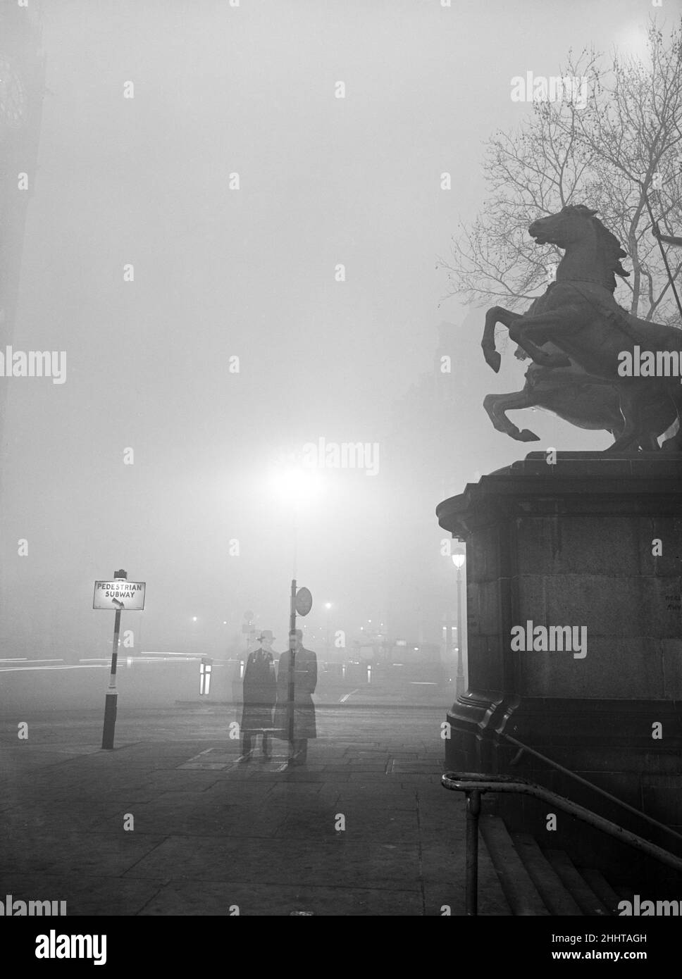 The great smog blanket - mixture of smoke and fog that is said to be costing £2,000,000 a day - thickened last night to what was described as the blackout of London for twenty-five years, possibly the worst ever. Pictured, Boadicea statue at Westminster. 8th December 1952. Stock Photo