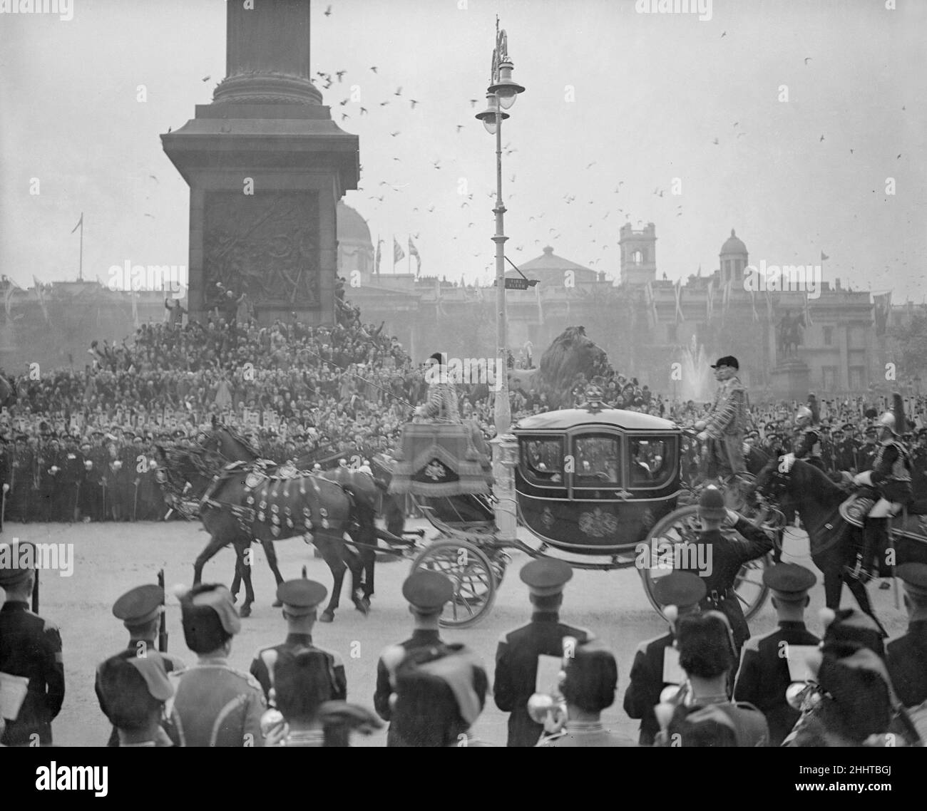 Coronation of King George VI.The procession passes through Trafalgar Square as thousands of people cheer from the side of the road. 12th May 1937. Stock Photo