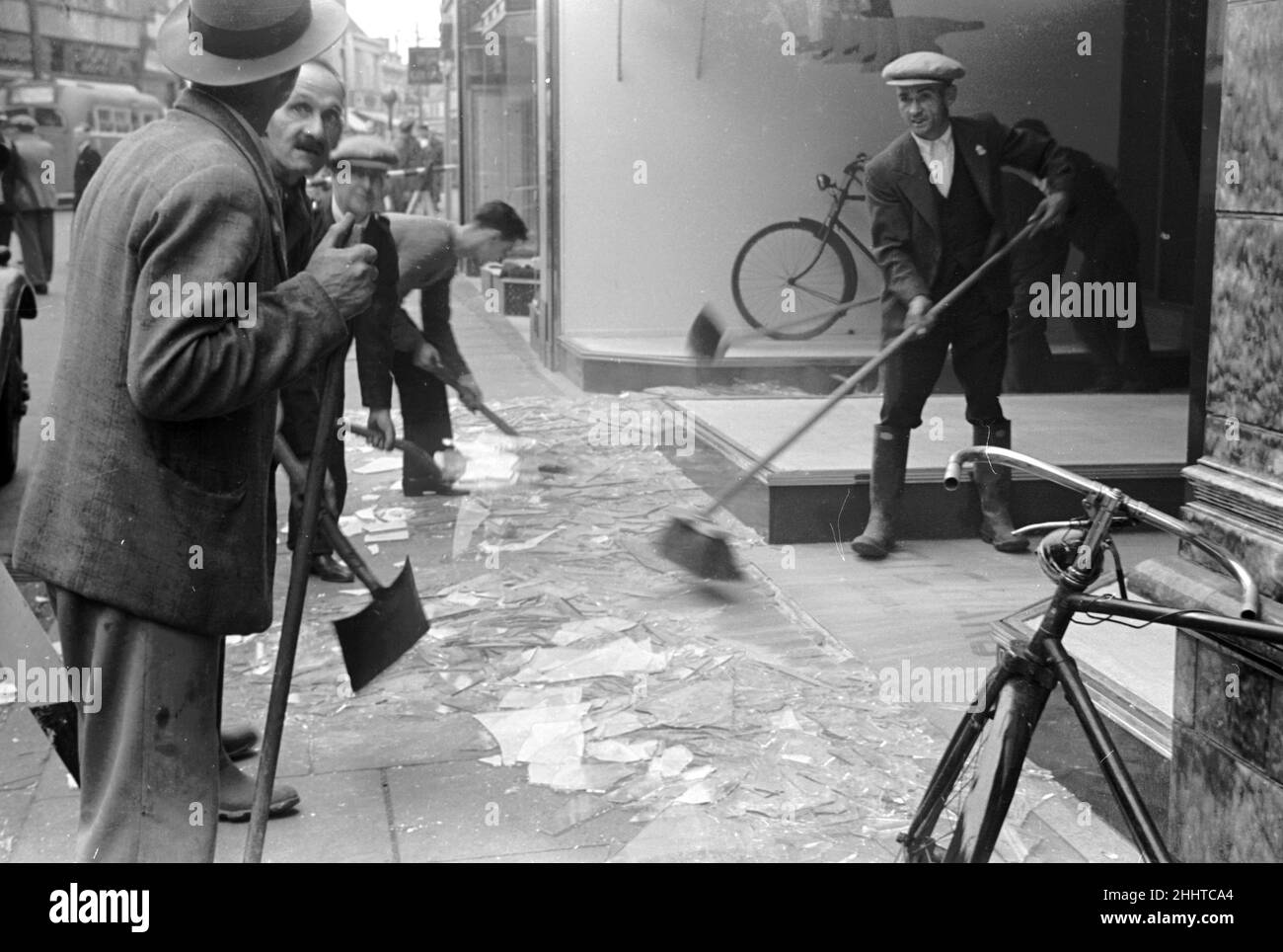 Alfieri. Air Raid damage, Kingston, London. Sweeping up broken glass from a damaged shop. August 25th 1940. L159 Stock Photo