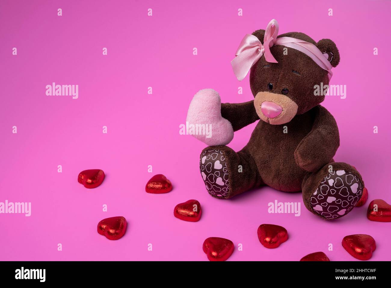 teddy bear teddy bear holds a fluffy heart in his paws. Pink background ...