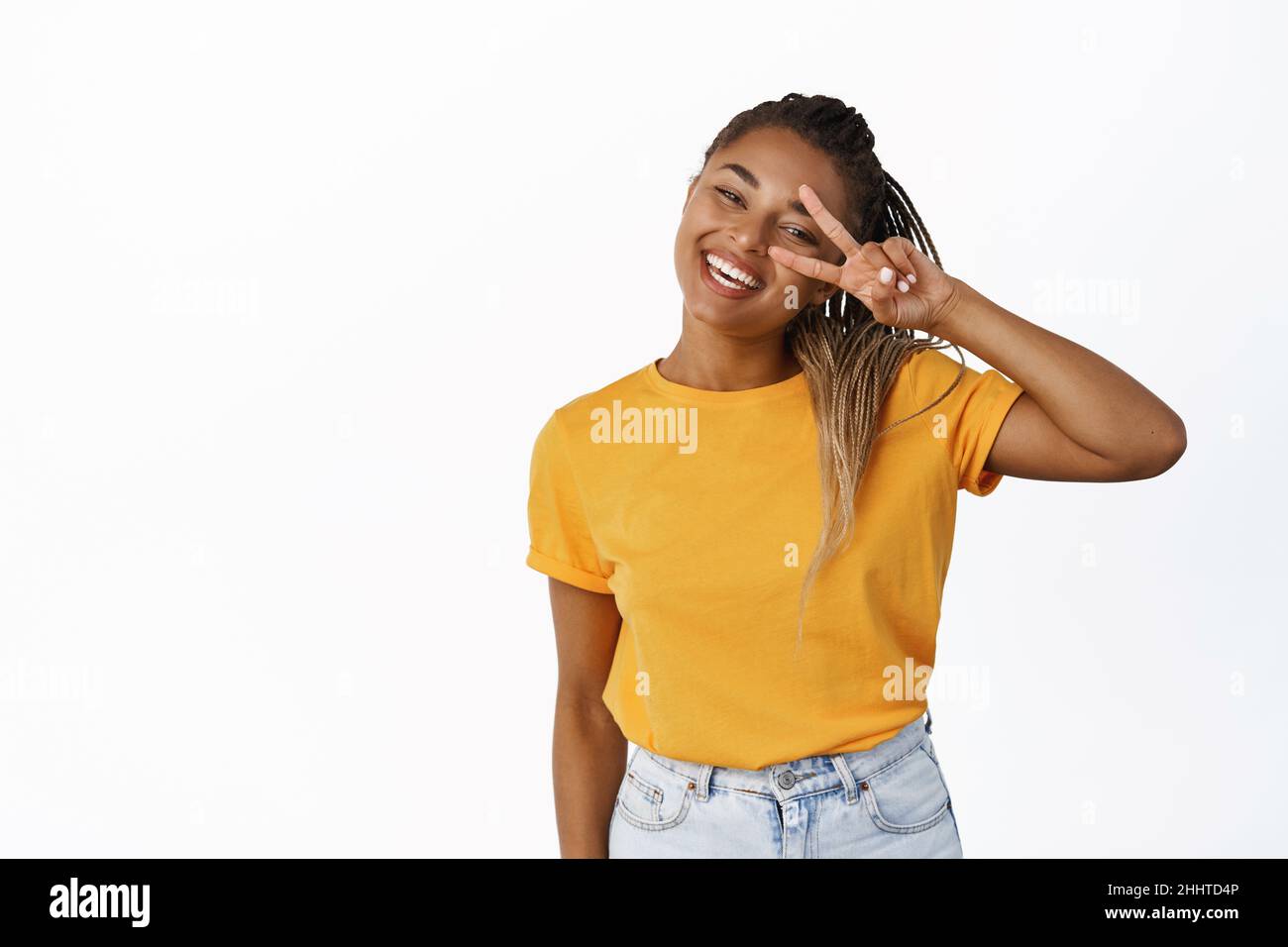 Positive Black girl shows peace, v-sign and smiling happy, wearing ...