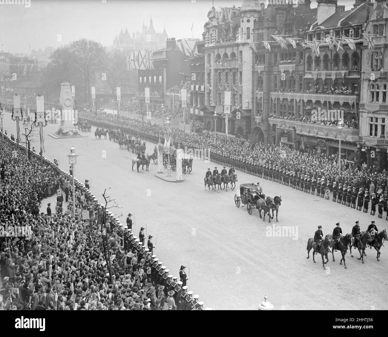 Coronation of King George VI. The procession passes the Cenotaph as it makes its way down Whitehall  as thousands of people watch from the side of the road. 12th May 1937. Stock Photo