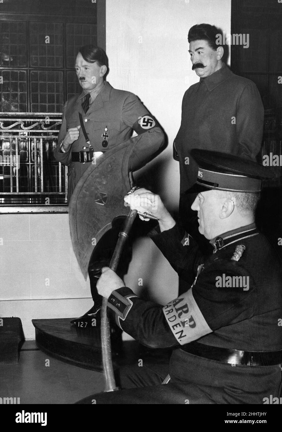 Waxworks of Hitler & Stalin are menaced by a member of the Madame Tussaud's Staff, who is also a ARP Warden, volunteer Air Raid Precautions Warden, shortly after the outbreak of the Second World War, pictured 18th October 1939 Stock Photo