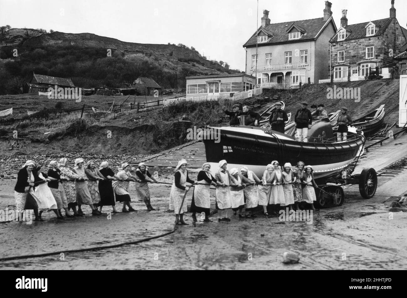 Women of Runswick Bay in Yorkshire, all pulling together on the rope to launch the lifeboat. 13th March 1940. Stock Photo