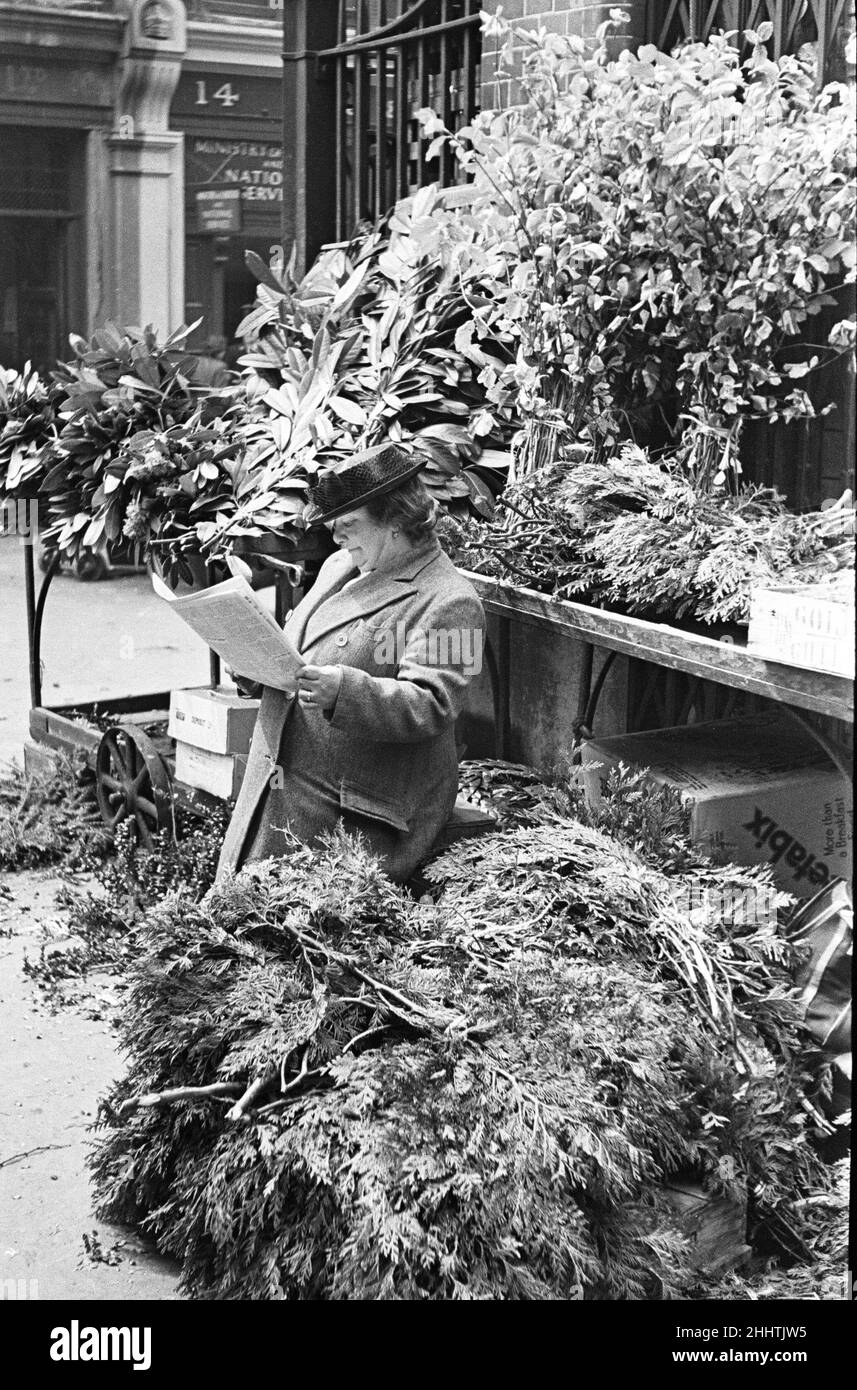 Day in the life of Covent Garden  Market Cirica 1948London, England. A flower lady with her flowers has a read of her paper in between her daily customers.  Picture taken 1st July 1948 Stock Photo
