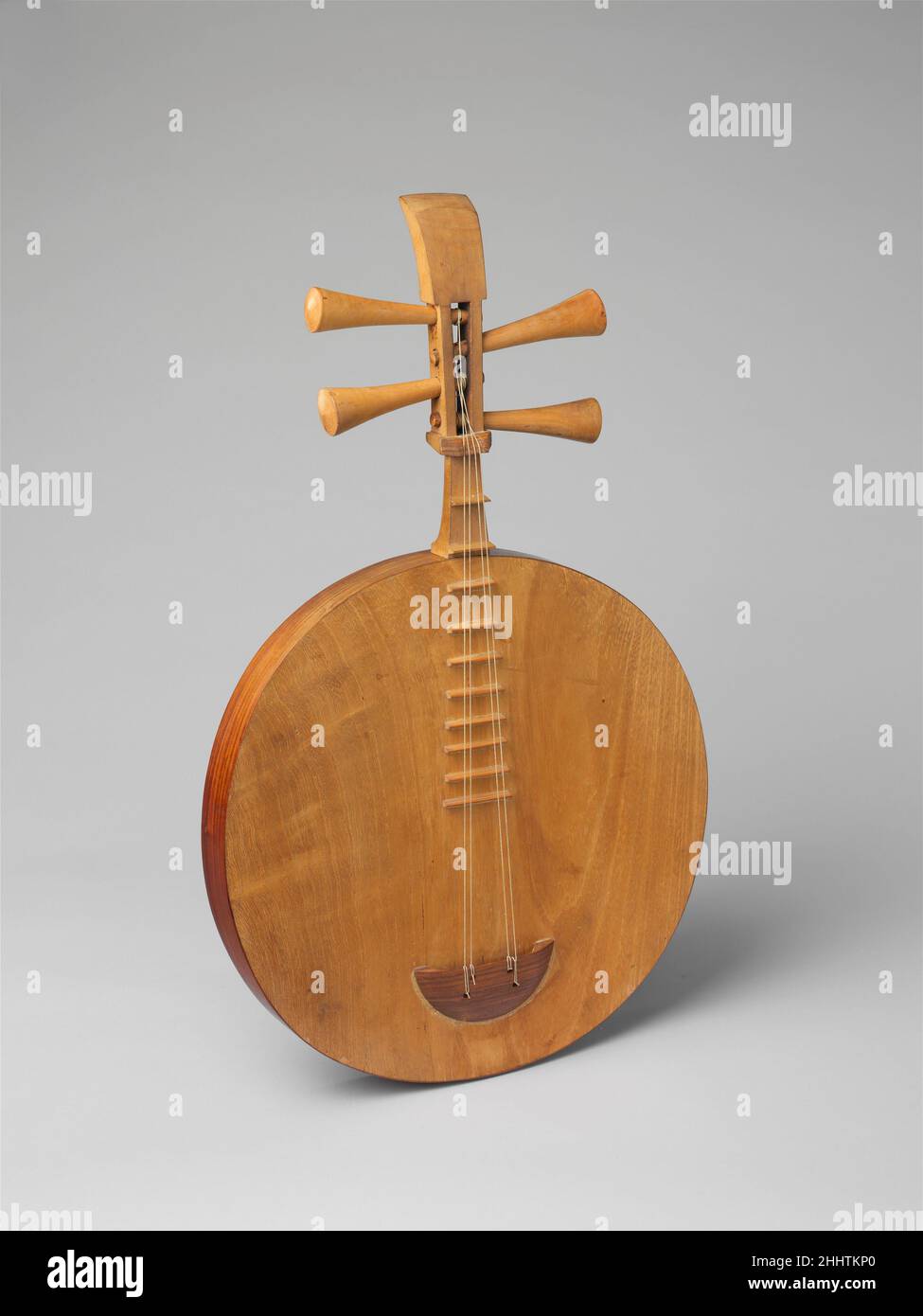 Yueqin (月琴) 19th century Chinese The resemblance of this round lute to the full moon (yue) gave it its name. The yueqin developed from a much larger long-necked lute that appeared in the Qin and Han dynasties. Its four strings are tuned in pairs, a fifth apart. Like the sanxian, it encloses a vibrating plate. Found in popular ensembles and the Beijing opera and used to accompany song, the yueqin has not been fully embraced by the modern Chinese orchestra. The player presses the strings between the high frets making chord playing difficult but giving increased control over the timbre and intona Stock Photo