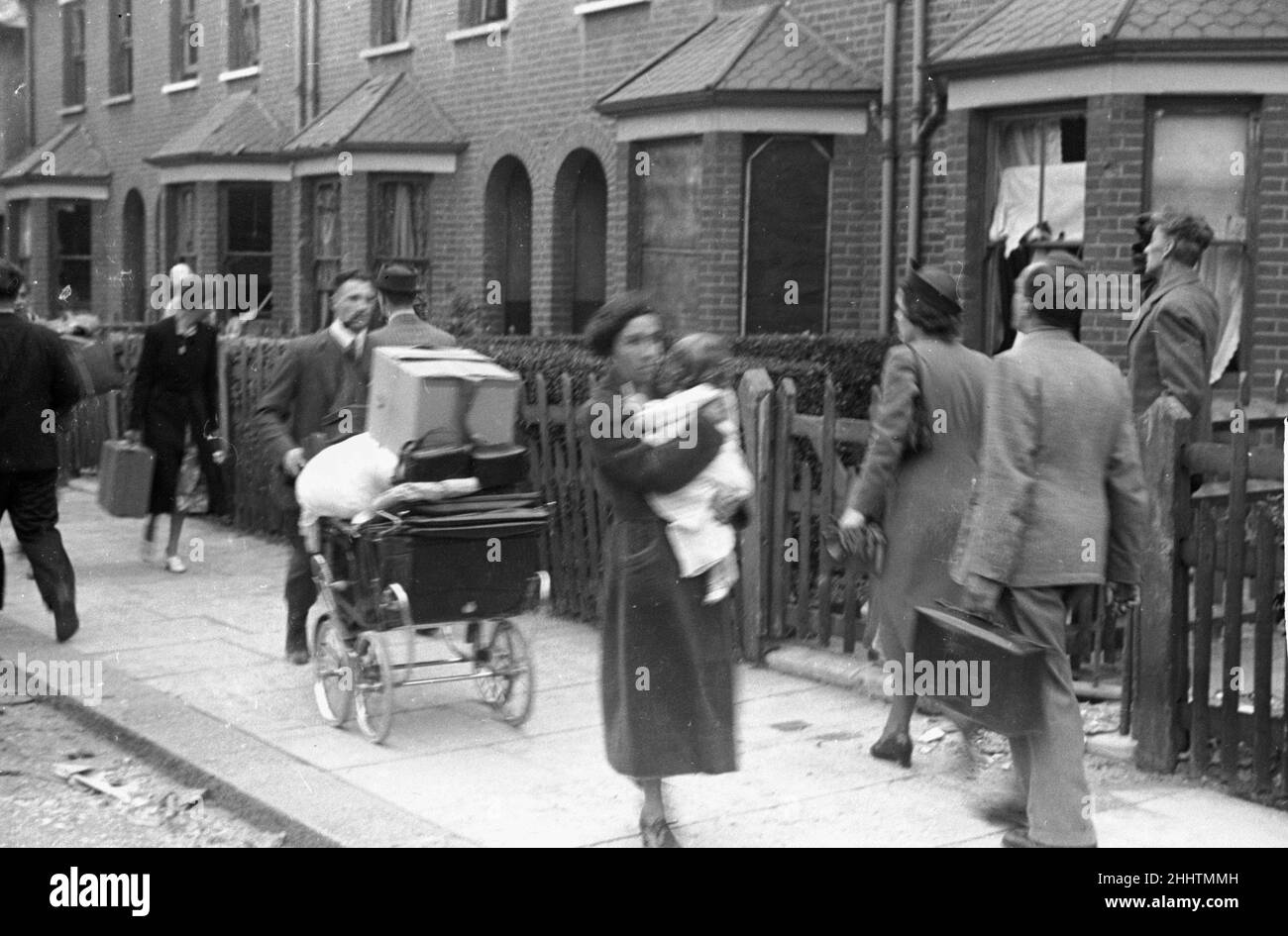 Alfieri. Air Raid damage at Malden, London. August 16th 1940. Residents walk down the street past damaged houses. L157-25 Stock Photo