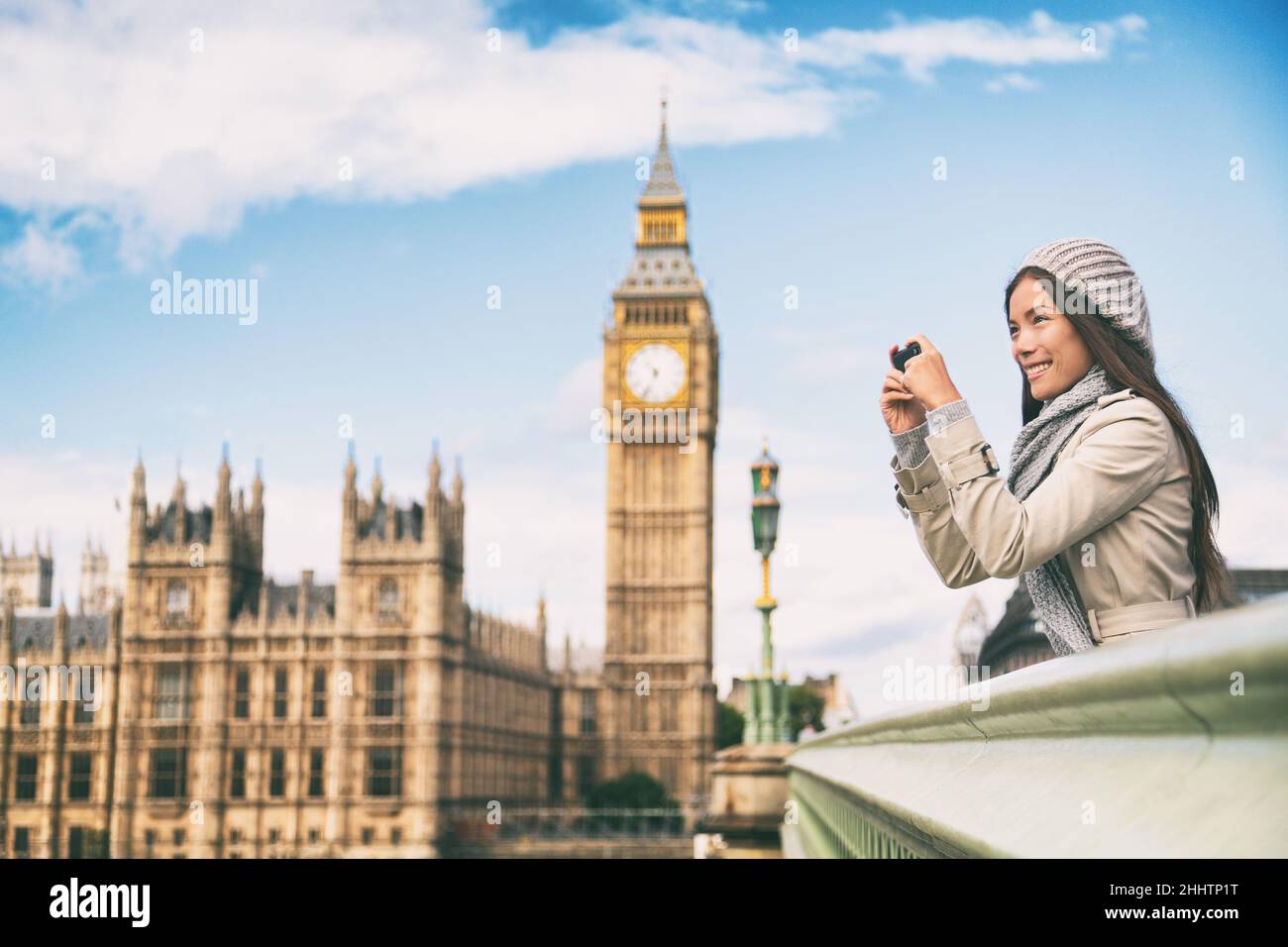 Travel tourist in london sightseeing taking photo pictures near Big Ben. Woman holding smart phone camera smiling happy near Palace of Westminster Stock Photo