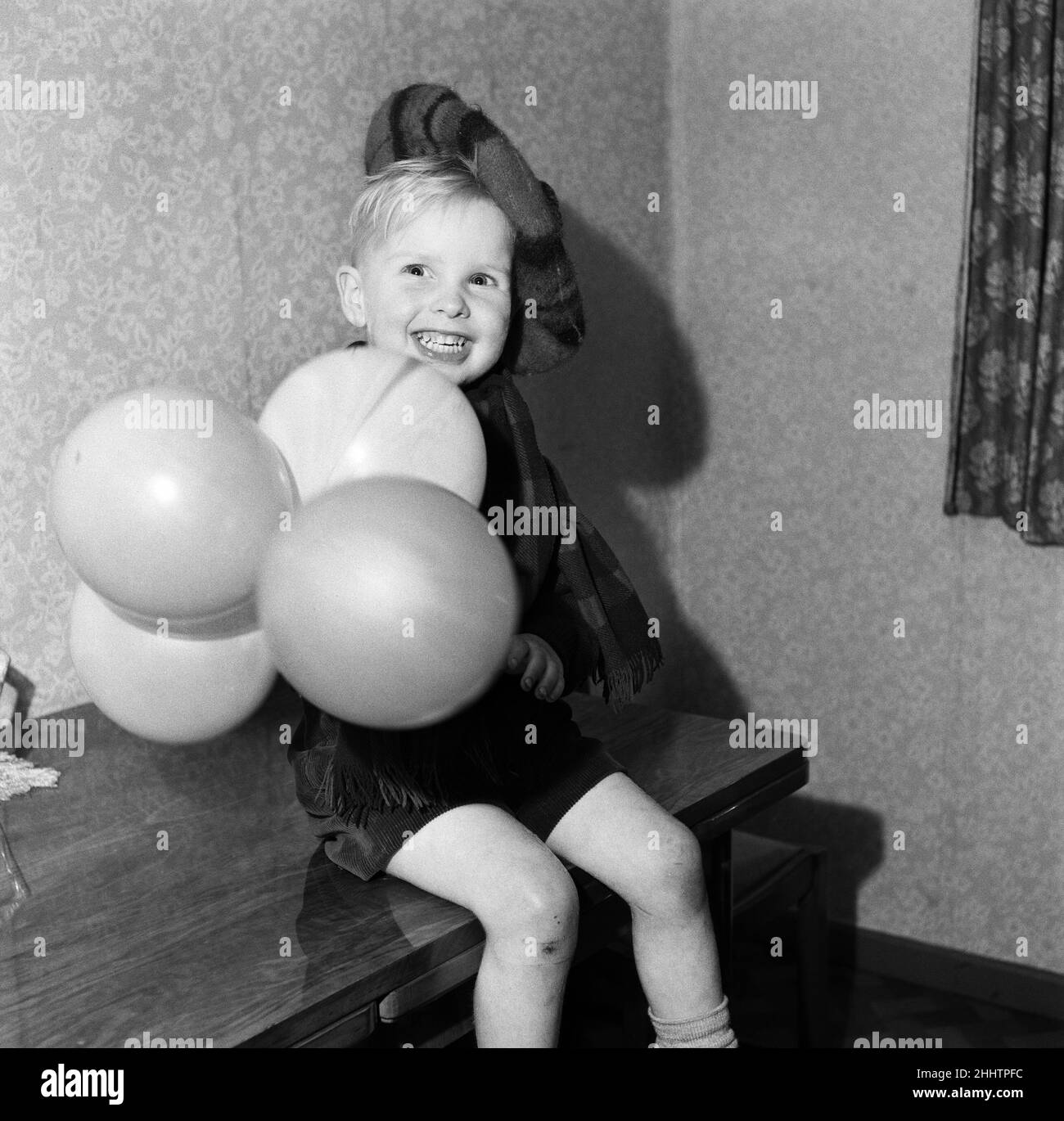 All dressed up in his Royal Stewart Tam O'Shanter hat and tartan scarf this happy 3 year old, Steve Lyons, looks forward to the new year with the time honoured 'A Guid New Year tae Ane an Aa'. 30th December 1954. Stock Photo