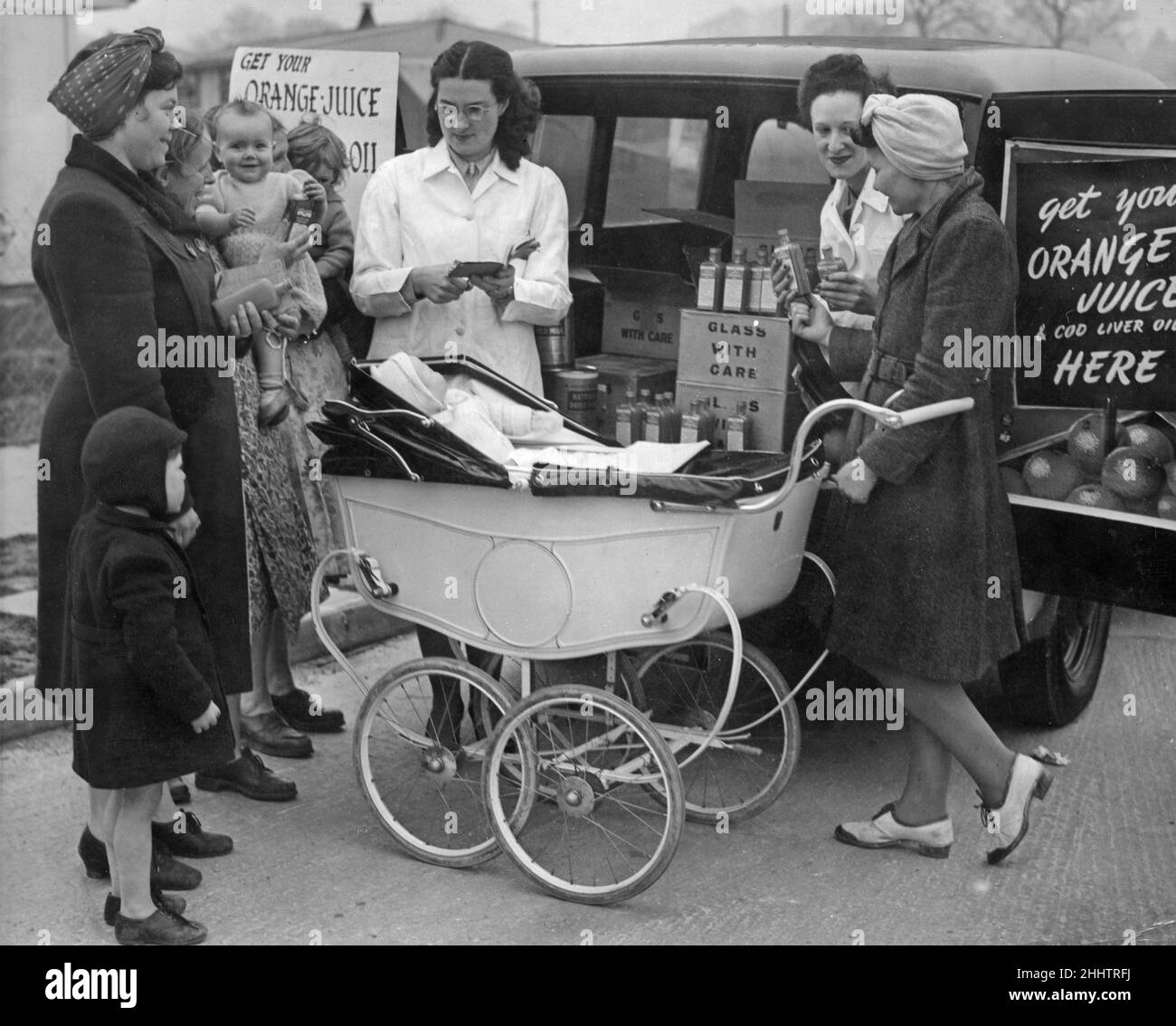 A mobile welfare van tours the districts of Birmingham without a District Welfare Centre. Picture shows mothers collecting their orange juice from the van at the Maypole prefab estate. 30th March 1949 Stock Photo