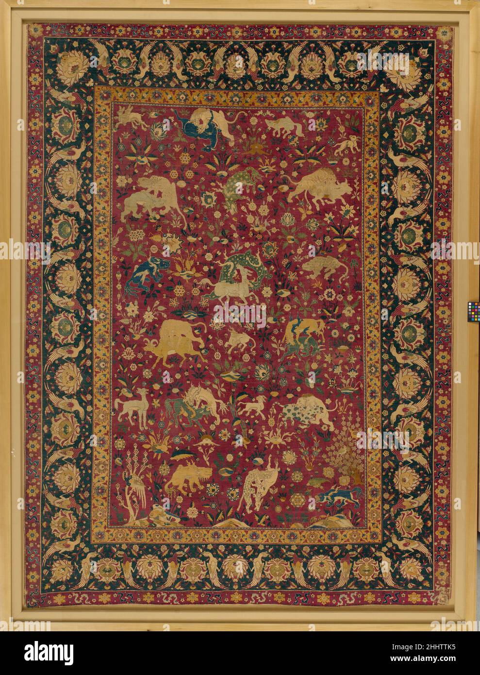Silk Animal Carpet second half 16th century This is one of a small group of carpets woven entirely of silk with approximately 800 knots per square inch, representing the highest level of production in sixteenth?century Iran. In contrast to the other floral and geometric carpets in this group, this outstanding example displays a painterly approach, with images of animals in combat against a background of flowering plants. The range of animals includes lions, tigers, and rams, as well as spotted dragons and horned, deerlike beasts borrowed from Chinese art. Similar imagery appears on manuscript Stock Photo