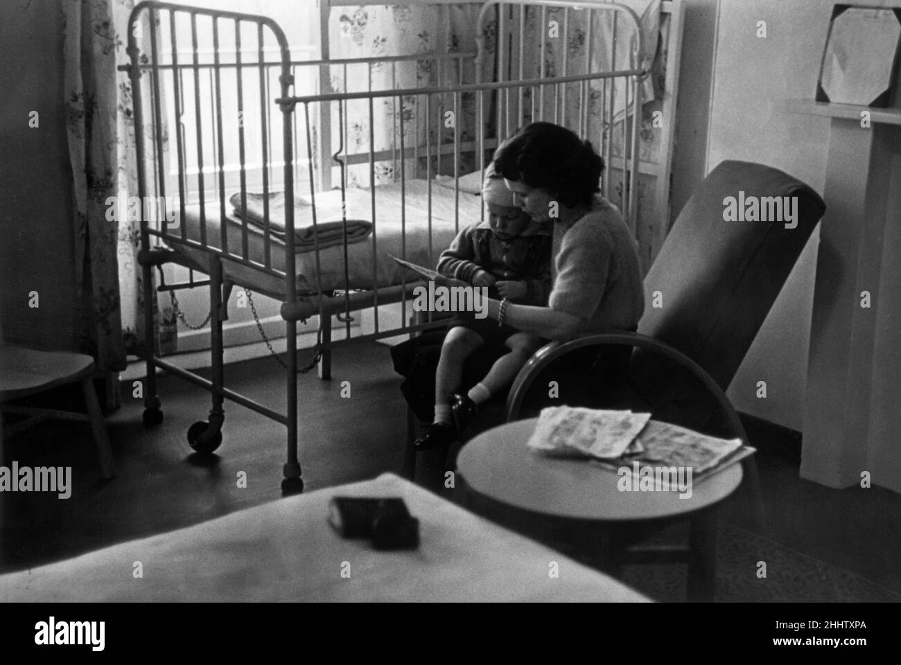 Young patient at a hospital after having an operation for gland trouble, improving under the direct care and attention of his mother. July 1948. Stock Photo
