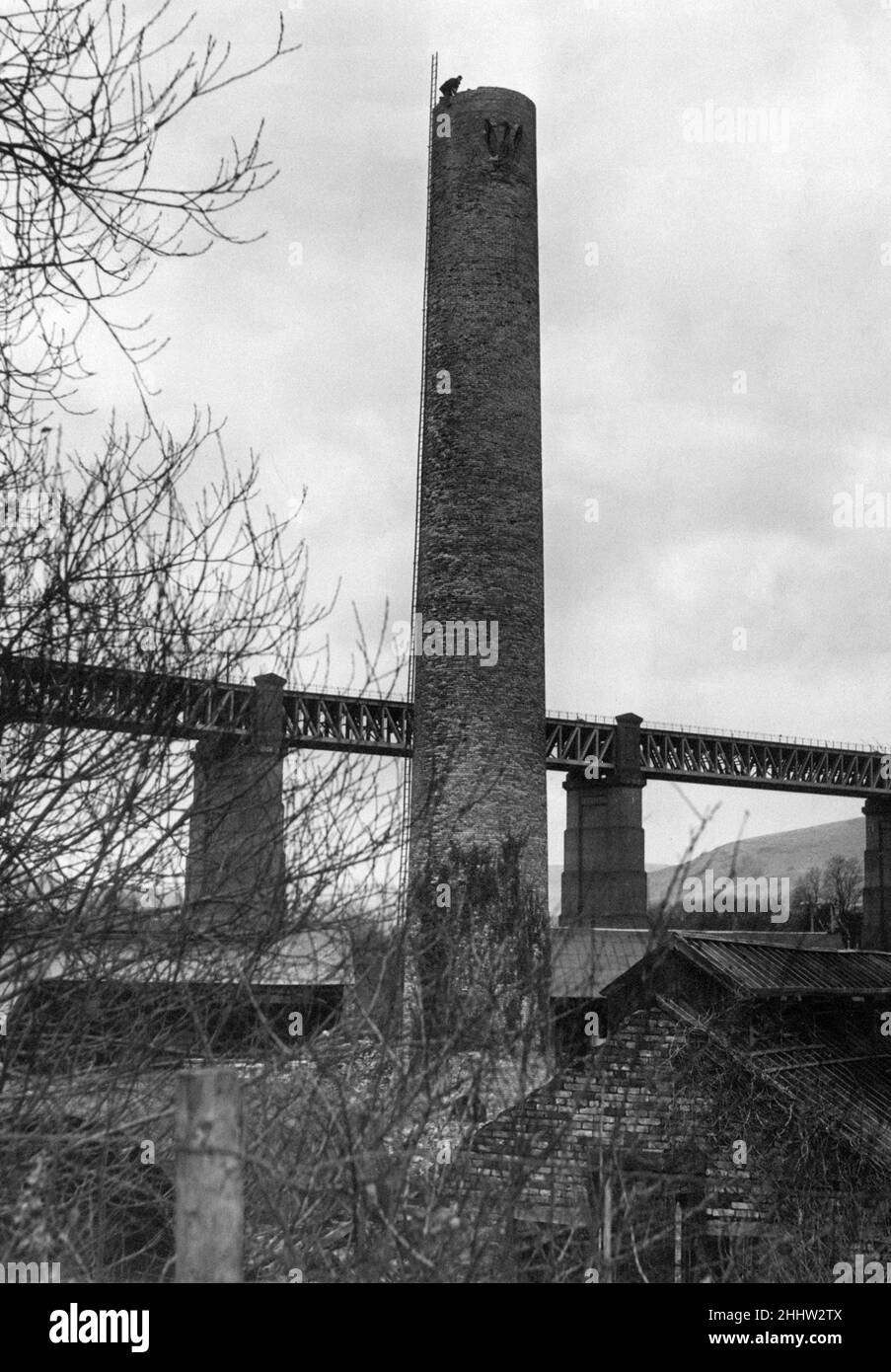 Walnut Tree Viaduct, a railway viaduct located above the southern edge of the village of Taffs Well, Cardiff, South Wales, Wednesday 9th January 1952. Made of Brick columns and Steel lattice girders spans.  Our Picture Shows ... Steeplejacks at work dismantling the stack of the old Melingriffith Tin Plate works at Taffs Well. Stock Photo