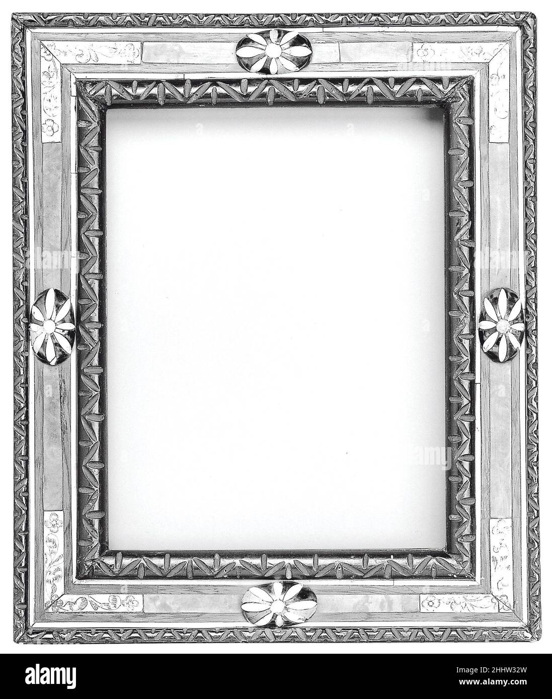 Cassetta frame early 20th century American, New York (?). Cassetta frame. American, New York (?). early 20th century. Basswood back frame with rosewood upper moldings and ivory, tortoiseshell, oak and maple veneers. Carved. Sight edge: simplified lotus leaf, ebonized. Frieze: ivory stringing, maple and oak veneer. Centers: oval bosses with ivory and tortoiseshell veneer. Corners: curled acanthus leaves and paterae engraved on ivory.. Frames Stock Photo