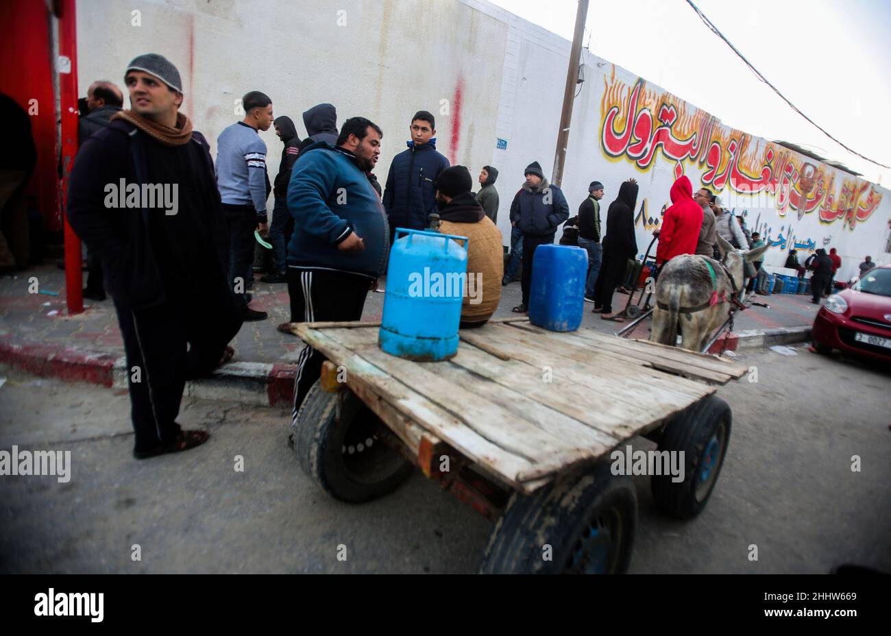 Gas cylinders are seen on top of a cart as Palestinians wait for their gas cylinders to be filled in front of big gas station. Shortage of gas and inability to fill the gas cylinders in their homes, which makes the winter difficult, as gas is one of the sources of heating. The crisis is repeated almost every year at this time as a result of the increasing need for gas, in addition to the lack of a strategic reserve of gas for the owners of the stations, the Gaza strip obtains gas either through the Rafah crossing from Egypt or from the Israeli side. Stock Photo