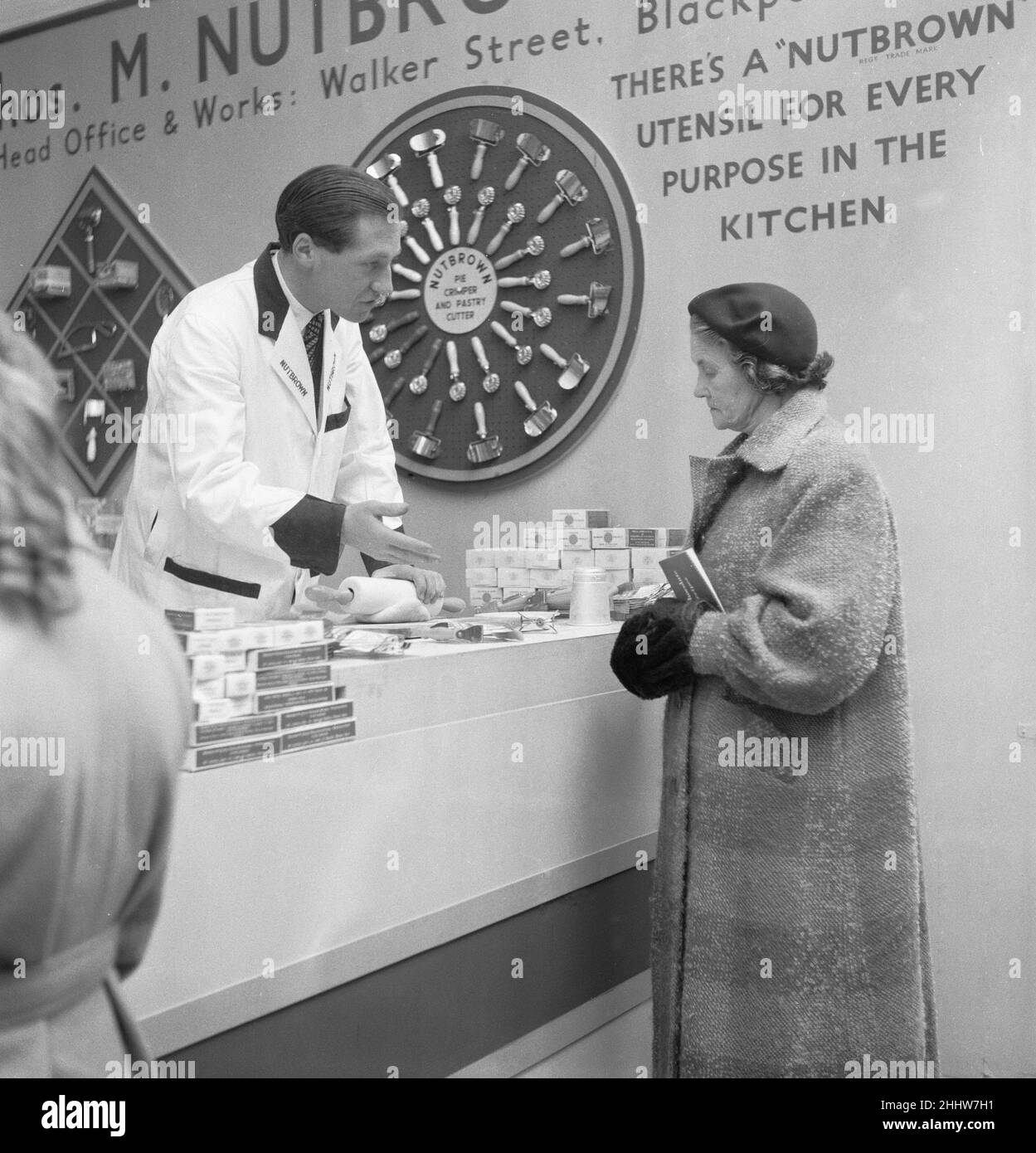 Ideal Home Exhibition Olympia. 3rd March 1955Salesman from Thos M Nutbrown Limited demonstrate the latest in rolling pin technology to a housewife. Stock Photo