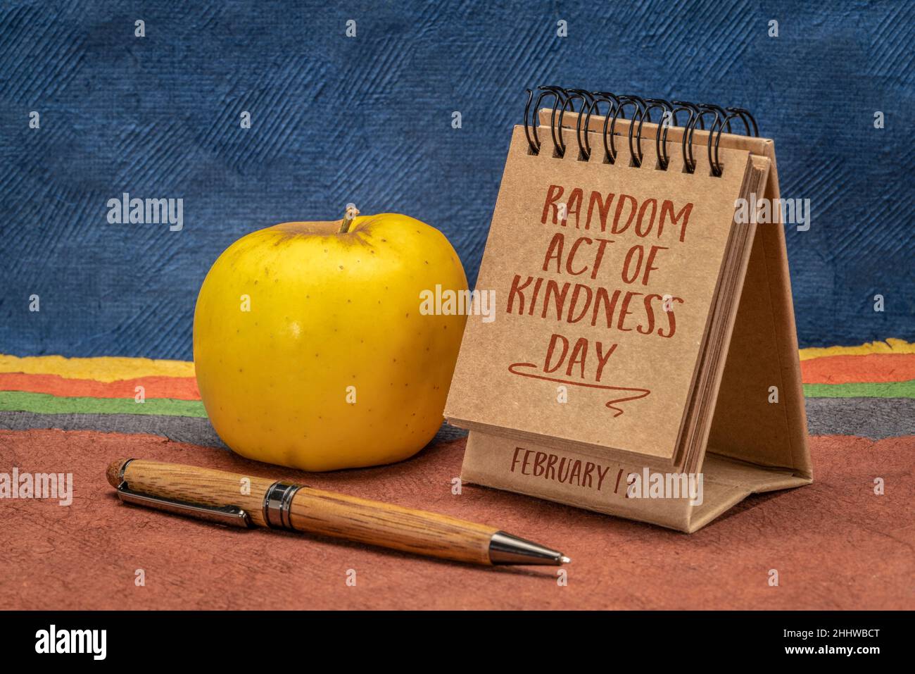 random act of kindness day inspirational reminder note - handwriting in a small desktop calendar against abstract paper landscape, social concept Stock Photo