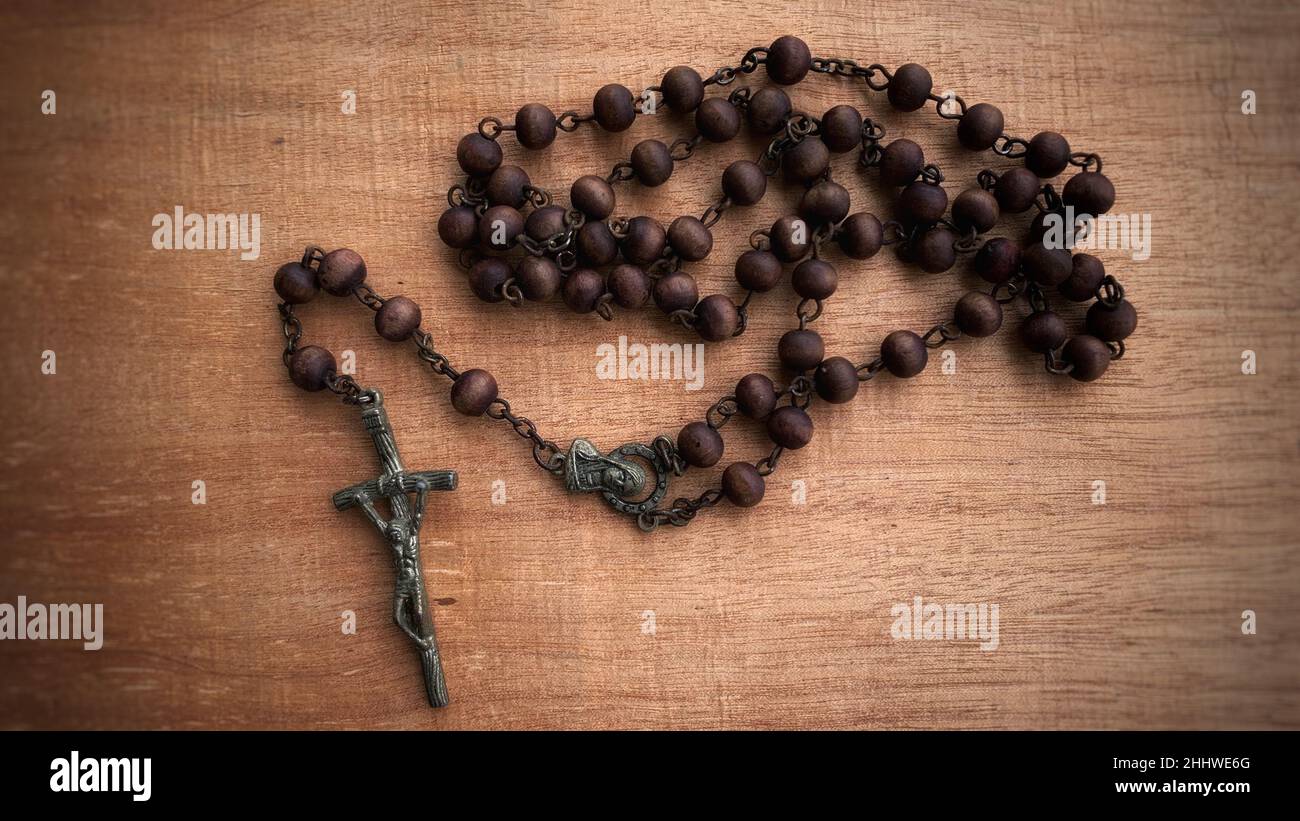 Top view of Holy Rosary on wooden table. Christianity concept. Stock Photo