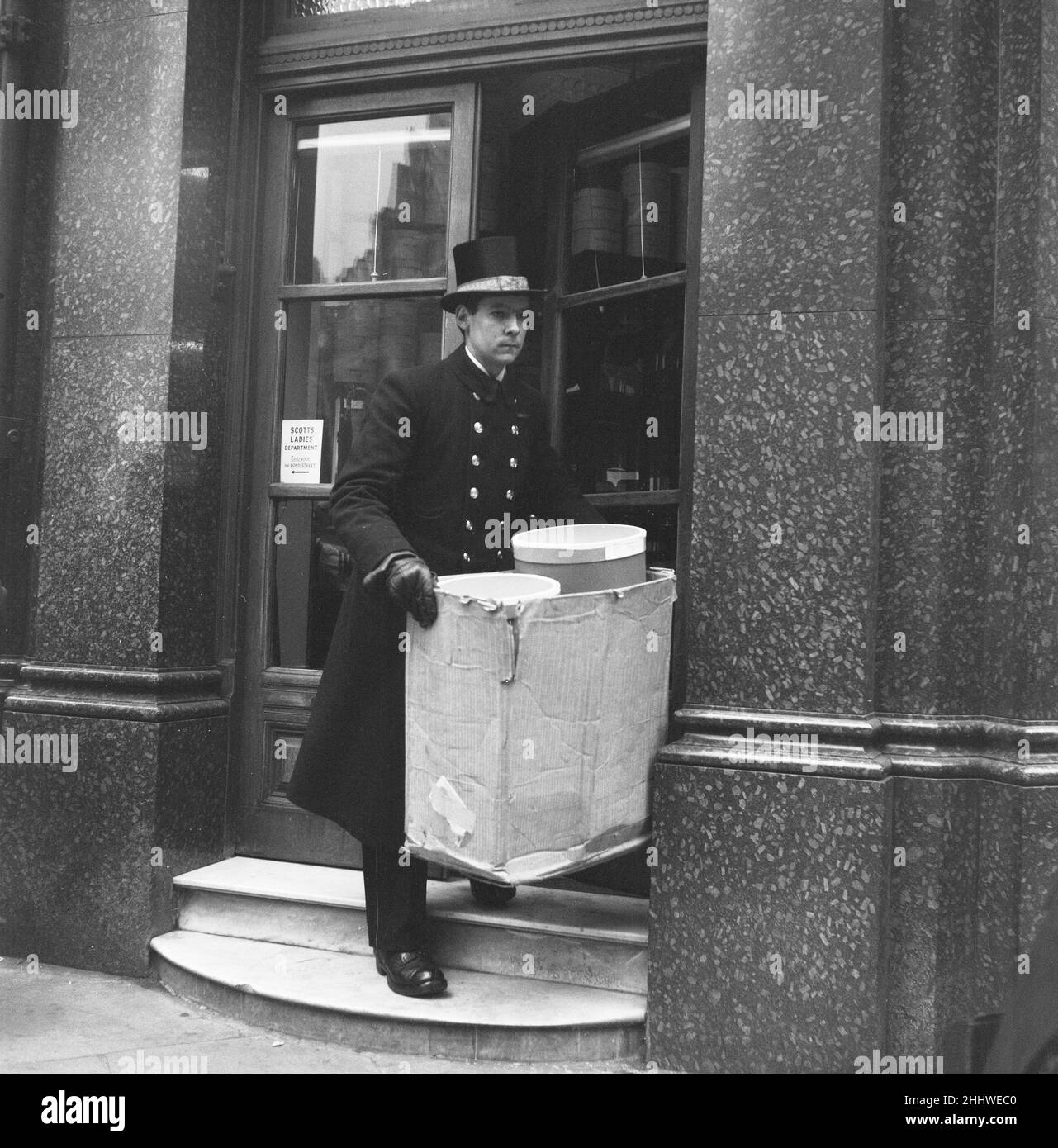 A Scotts' the Hatter delivery man seen here dressed in full dress uniform, loading the days deliveries to London clients. 19th March 1954 Stock Photo