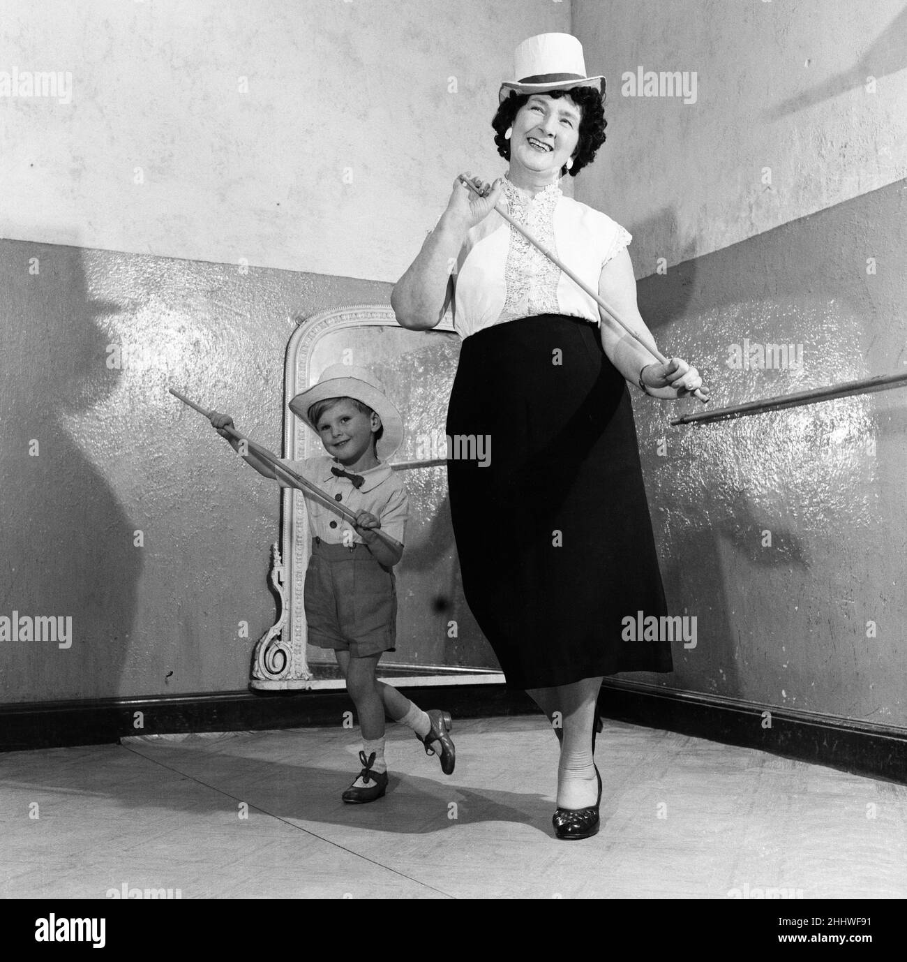 A grandmother teachers her grandson how to dance. 21st June 1955. Stock Photo