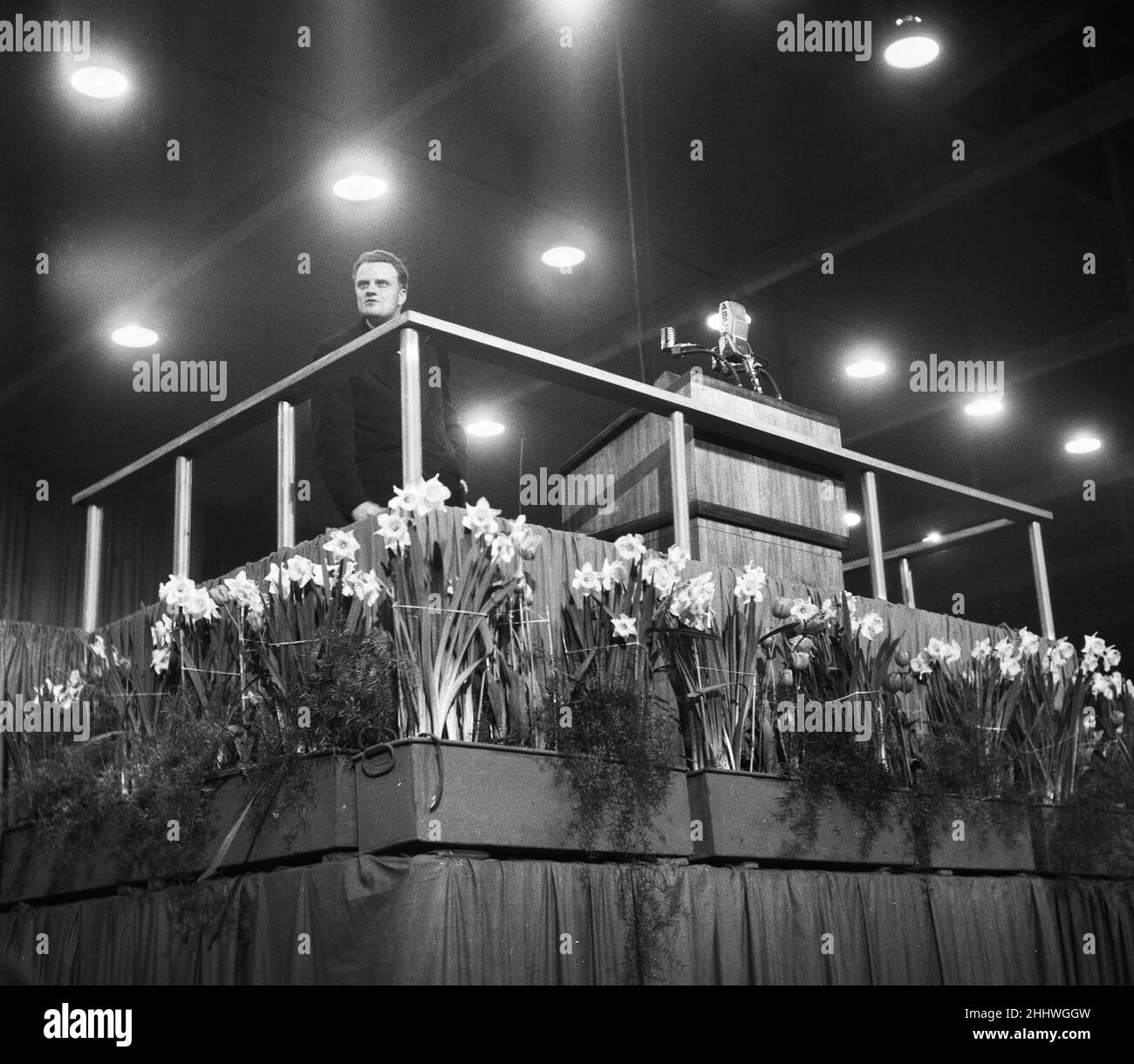 American evangelist Billy Graham addressing a huge crowd of people at Kelvin Hall in Glasgow, Scotland during his Scottish Crusade. 23rd March 1955. Stock Photo