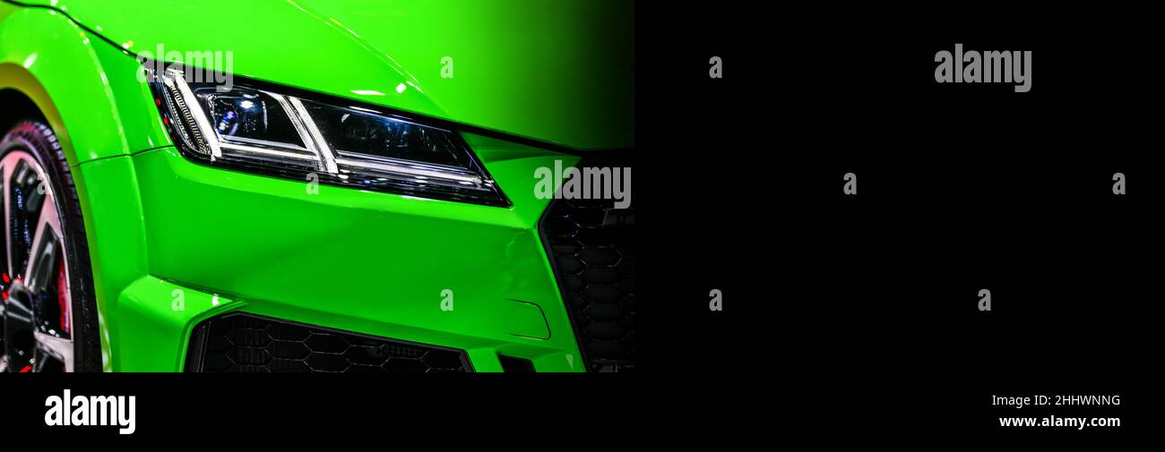Front view of the LED headlights modern green car on black background, copy space Stock Photo
