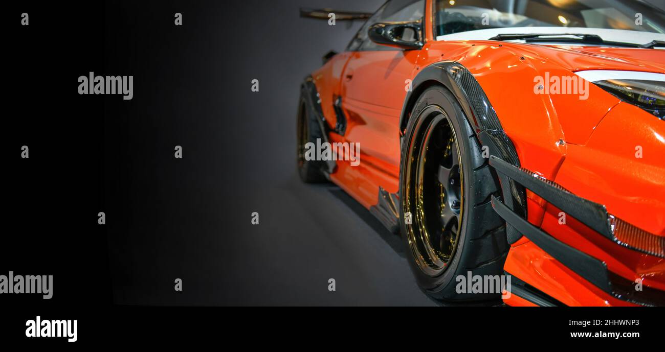 Front headlights of orange modify car on black background, copy space Stock Photo