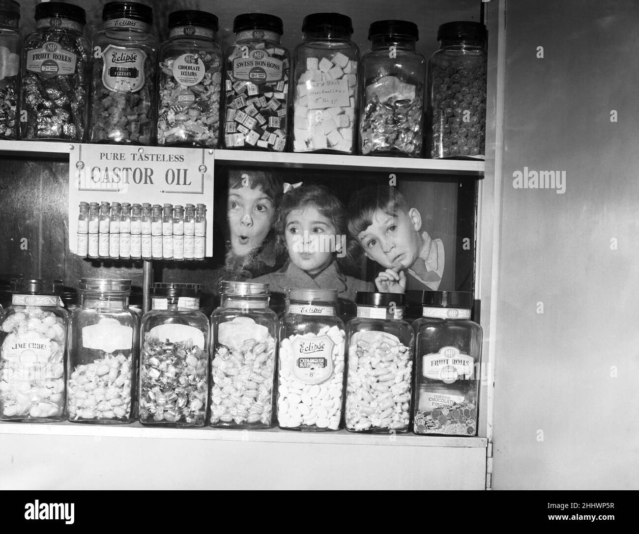 Children pressing their noses against the window of 'Mary's' sweet shop, Anniesland, Glasgow. Left to right, Michael Martin (7), Georgia Allison (4) and Theo Templin (5). 15th November 1954. Stock Photo