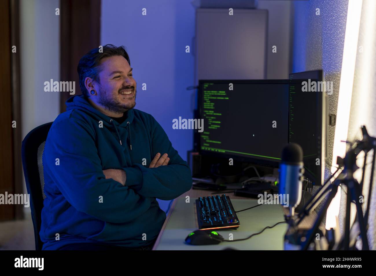 Computer programmer sitting happily in front of computer monitors Stock ...