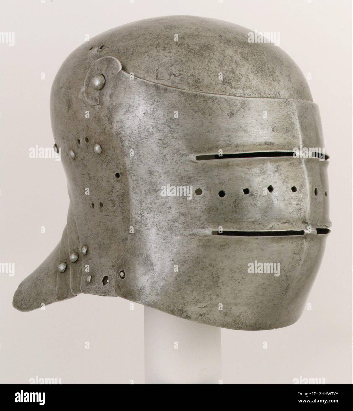 Sallet ca. 1510 German or Austrian, Innsbruck Developing from the late Gothic German sallet, characterized by a horizontal profile and pointed tail, this early-sixteenth-century example has a taller, rounder, and more compact form, a transformation that reflects Italian influence. The large visor, pierced for sight and ventilation, has an unmistakable masklike quality. Pairs of holes at the top and sides of the bowl allowed for the exit of the lining laces, by which the padded lining (now missing) could be adjusted from the outside for a comfortable fit. A similar sallet in the Museum's collec Stock Photo