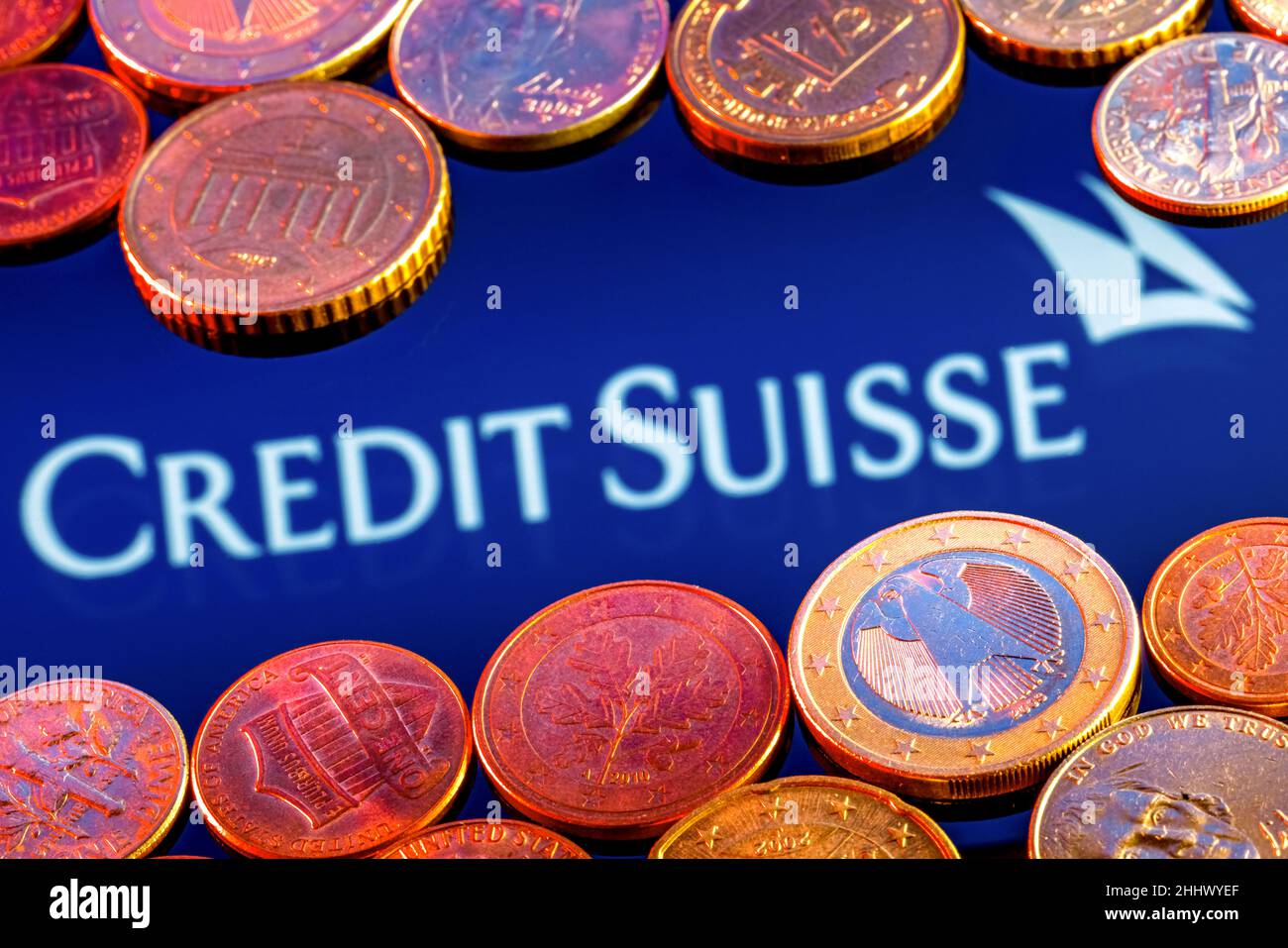 Variety of metal coins on background of Credit Suisse bank logo Stock Photo