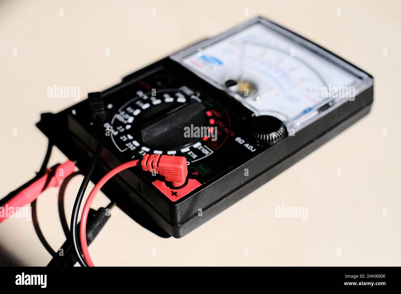 Analog multimeter measuring equipment for checking the amperage voltage at circuit breakers and wiring systems on main power distribution boards. Stock Photo